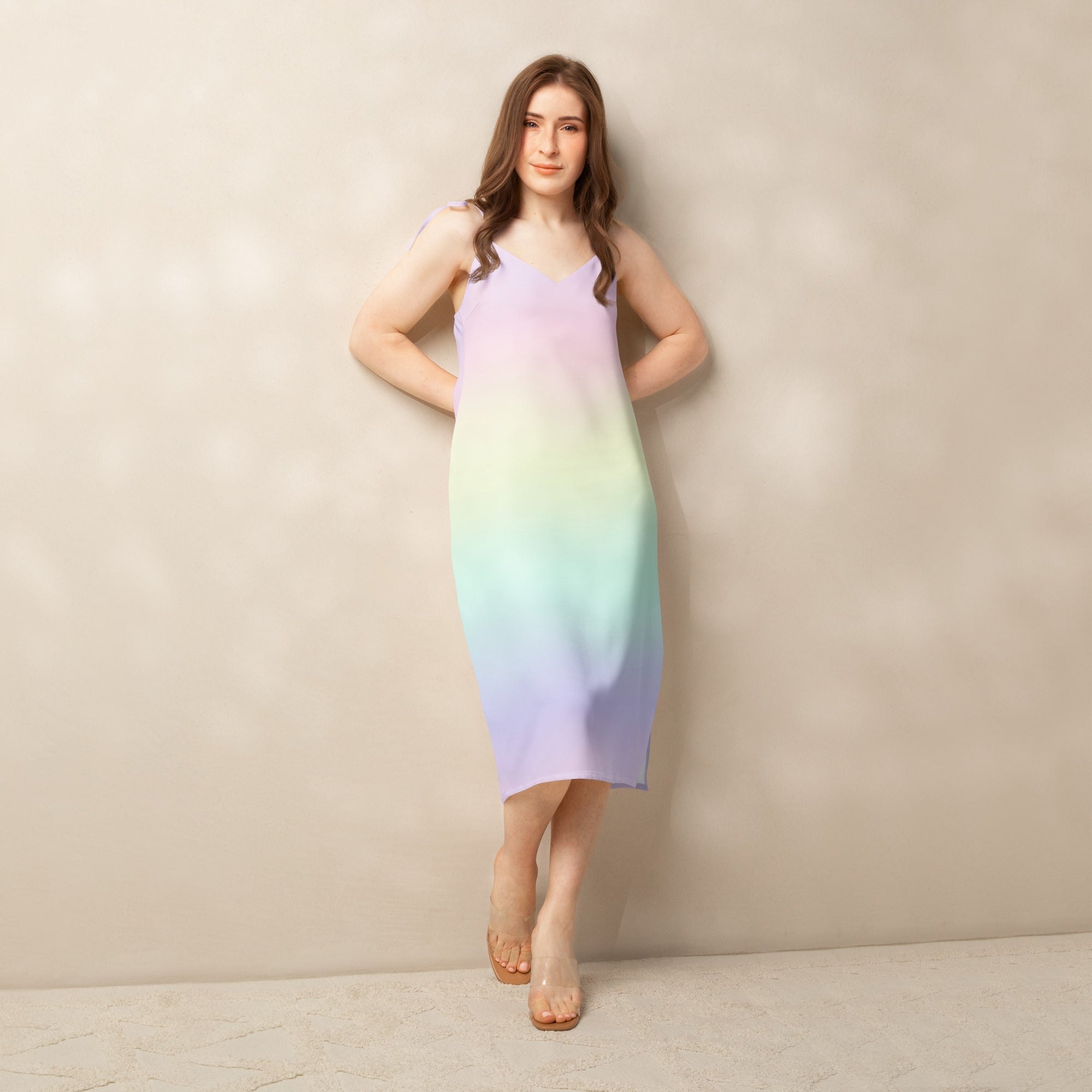 A flowing sleeveless midi slip dress with adjustable tie straps and pastel gradient from lavender to mint green and blue