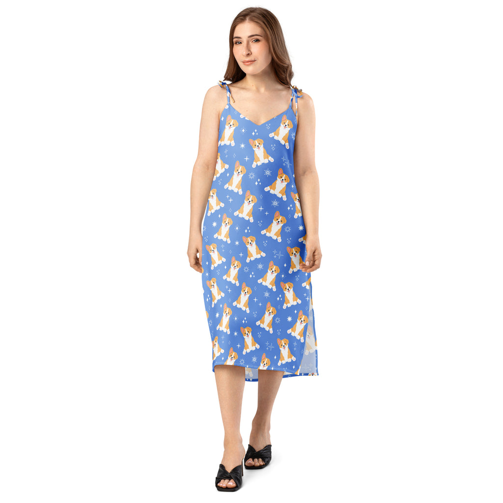 Women’s blue sleeveless midi slip dress with adjustable tie straps and playful corgi dog and snowflake pattern