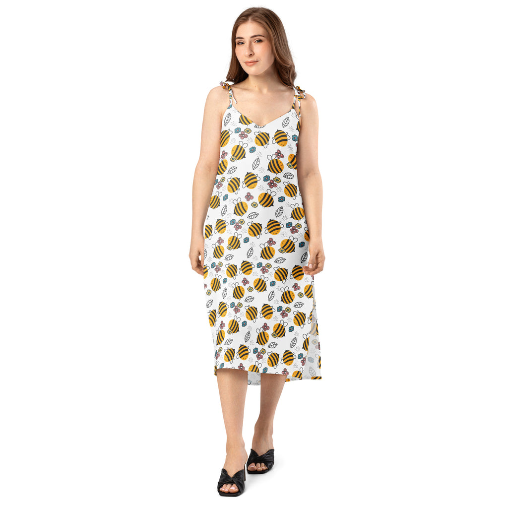 White sleeveless midi slip dress with yellow and black bumblebee pattern floral print adjustable tie straps and built-in bra