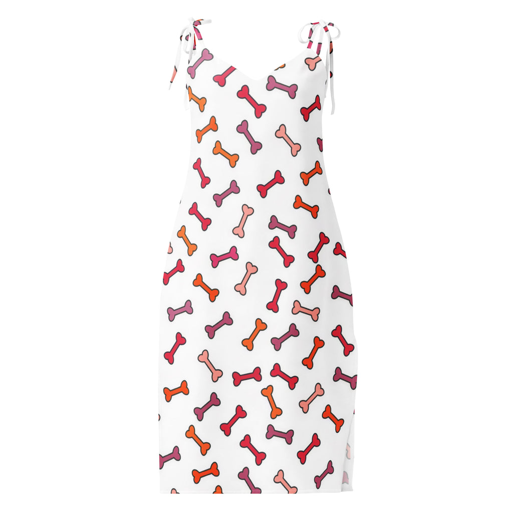 White sleeveless midi dress with v-neckline and adjustable tie straps featuring a colorful multicolored dog bone pattern
