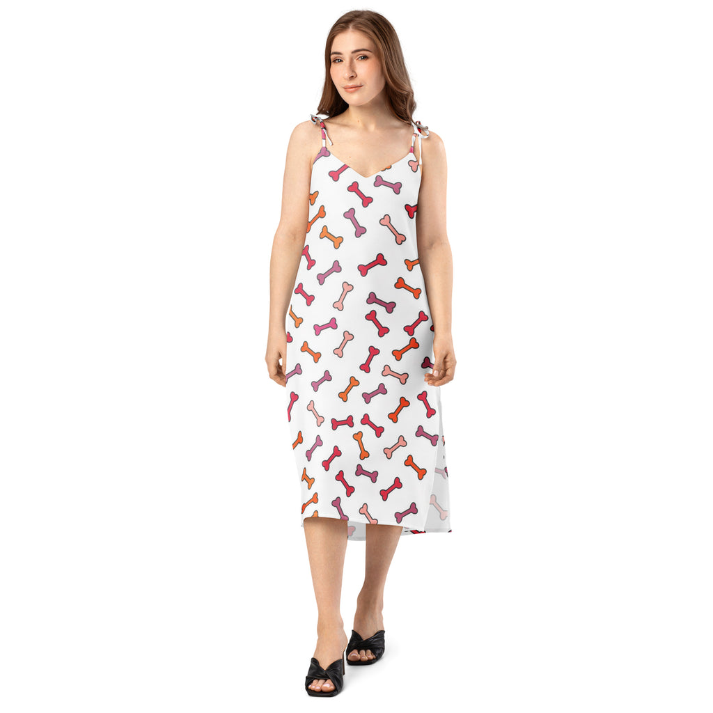 White sleeveless midi slip dress with colorful pink orange red dog bone pattern and adjustable tie straps and built in bra