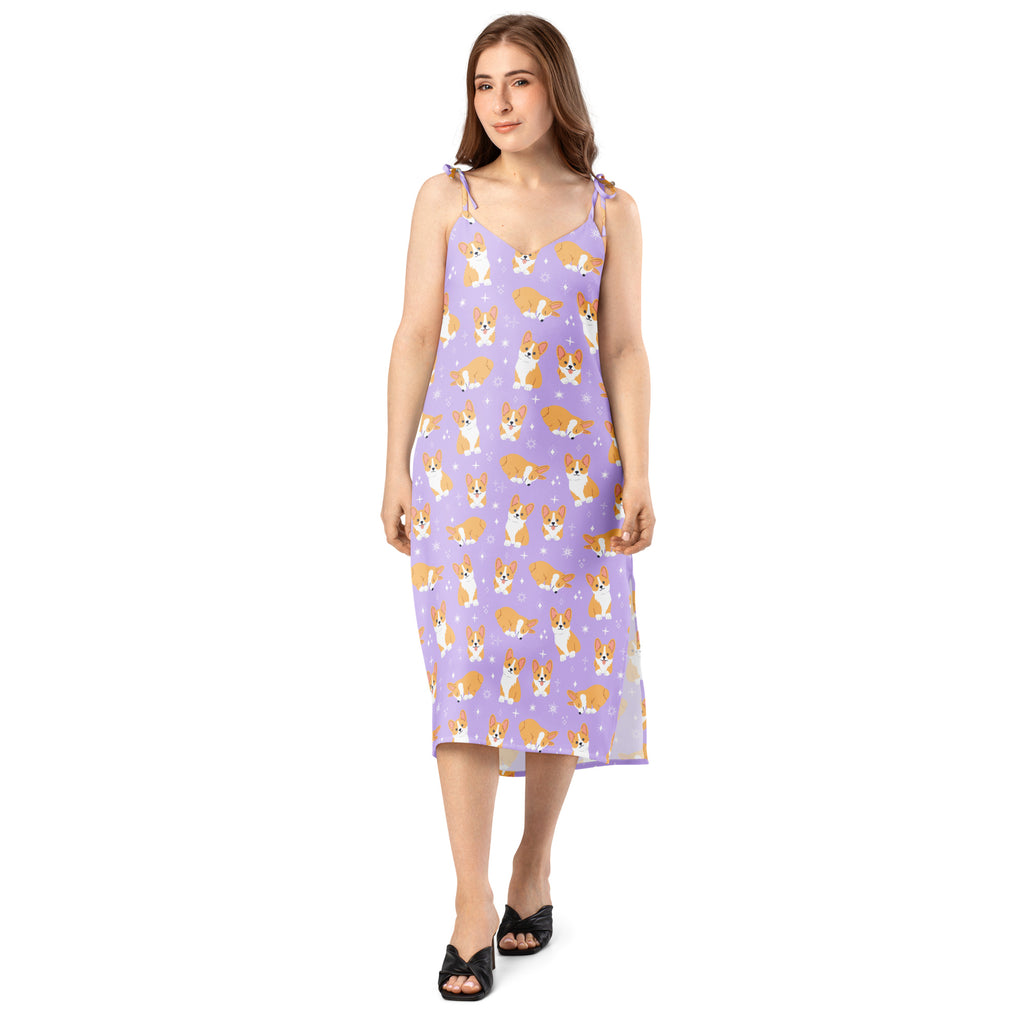 Woman wearing a purple slip dress with corgi pattern on a white background