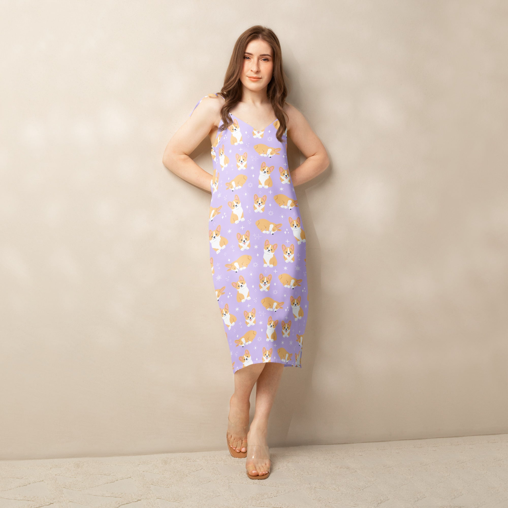 Woman wearing a sleeveless dress with corgi pattern against a beige background
