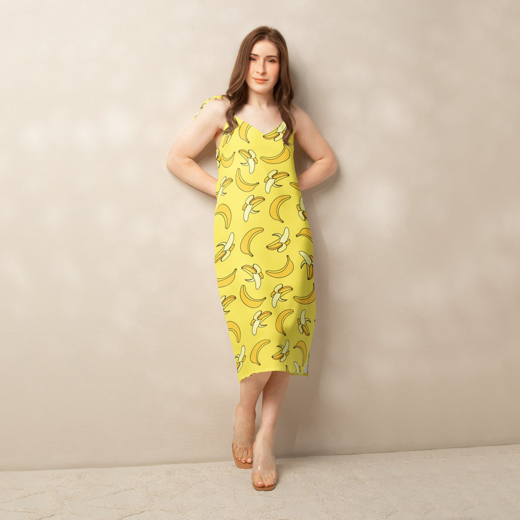 Woman wearing a yellow dress with banana pattern against a beige background