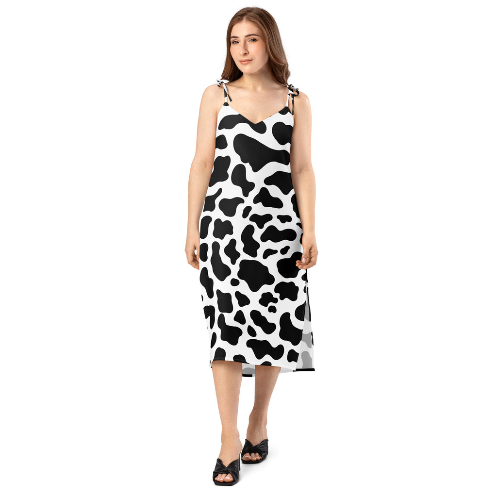 Woman wearing a black and white cow print dress on a white background