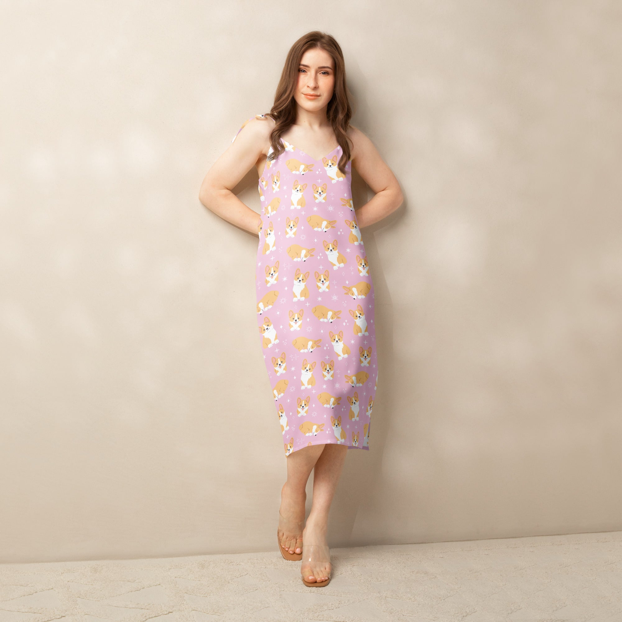 Woman wearing a pink dress with dog pattern against a beige background