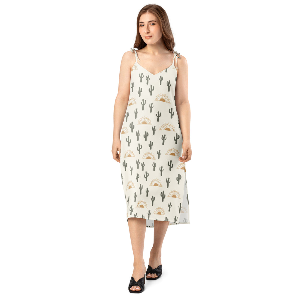 Women’s off-white midi sundress with black cactus and gold sun patterns featuring adjustable tie straps and built-in bra