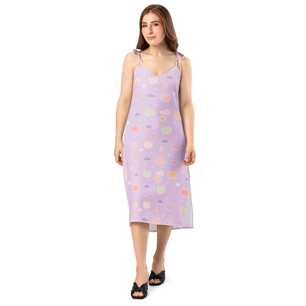 A lavender sleeveless midi slip dress with adjustable tie straps and pastel cartoon cats and clouds pattern