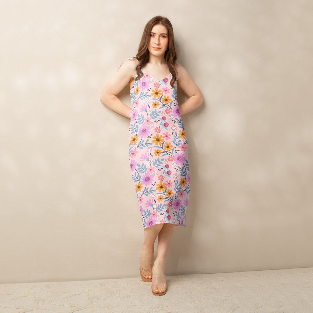 Women’s pink floral slip midi dress with adjustable tie straps and built in bra featuring yellow and purple flowers