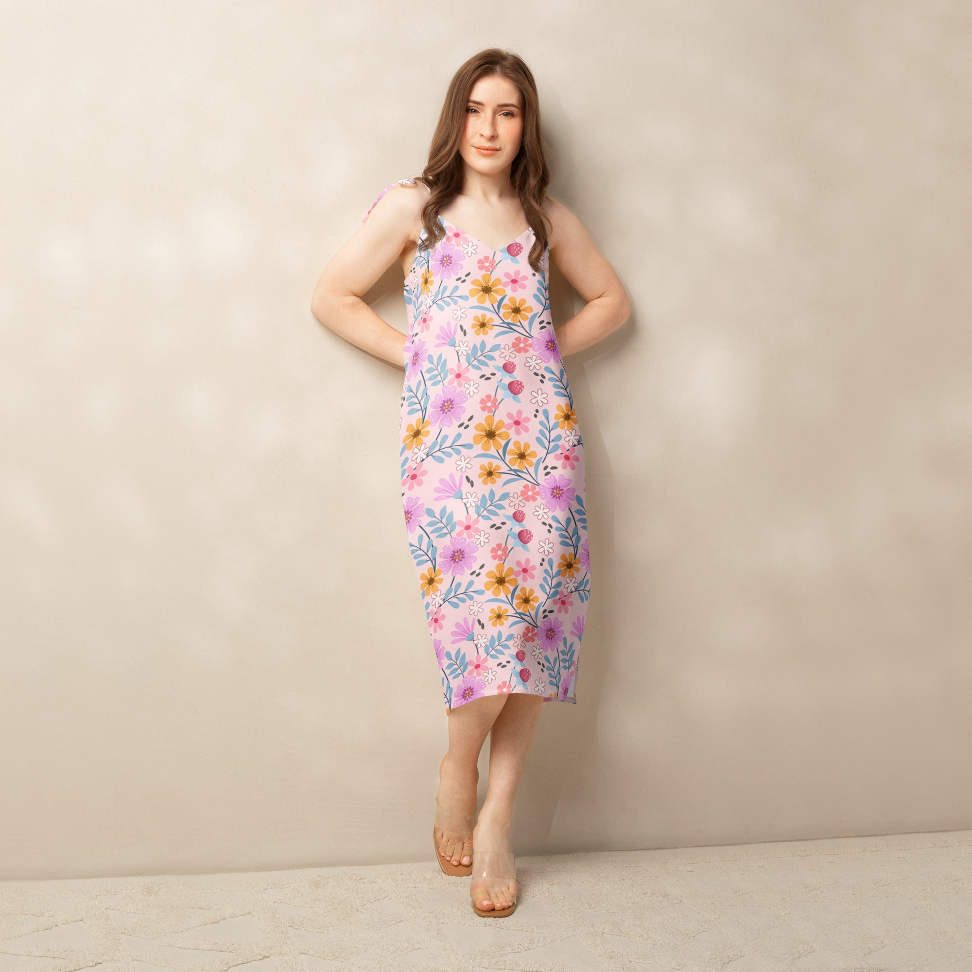 Women’s pink floral slip midi dress with adjustable tie straps and built in bra featuring yellow and purple flowers