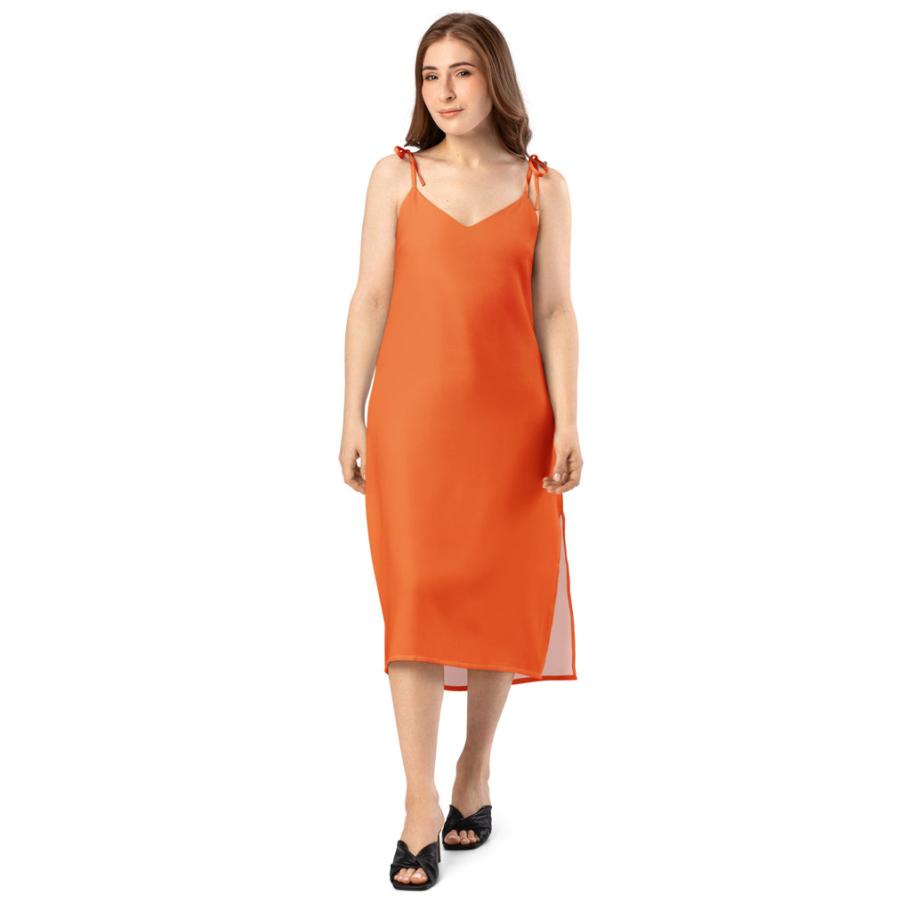 Woman wearing a coral slip dress on a white background