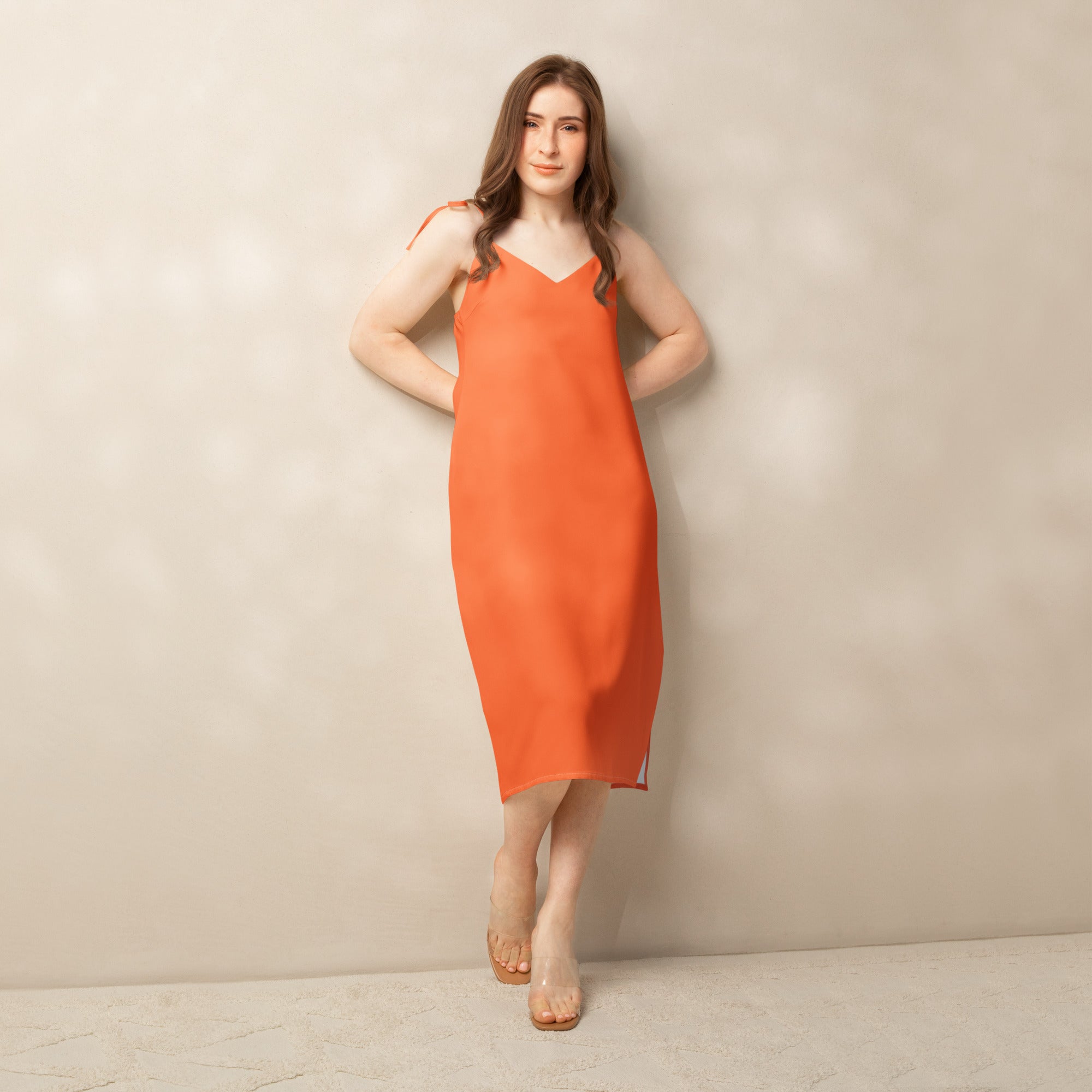 Woman wearing an orange dress against a beige background