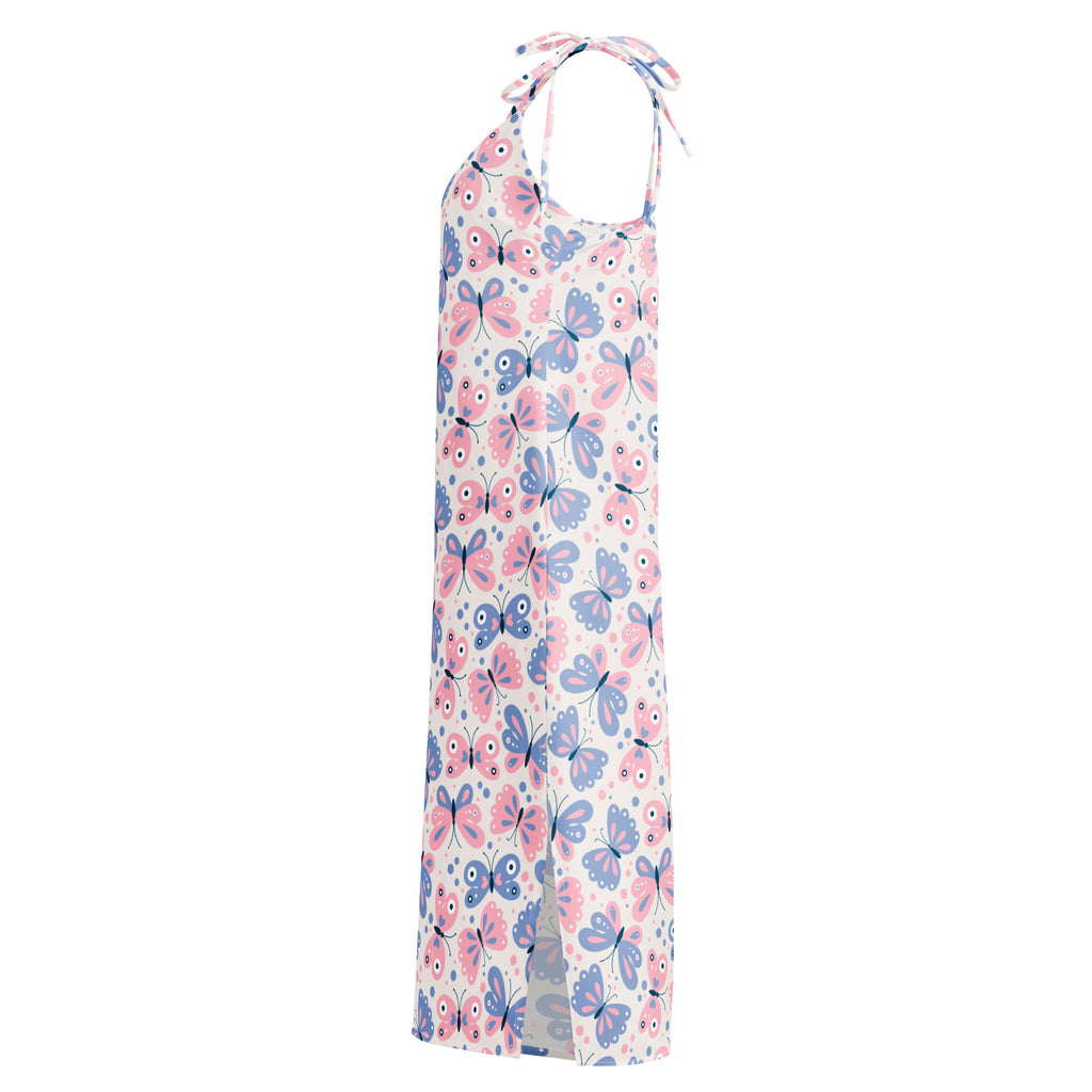 A flowing halter neck maxi dress in soft white fabric with pink and blue butterfly print and adjustable tie straps