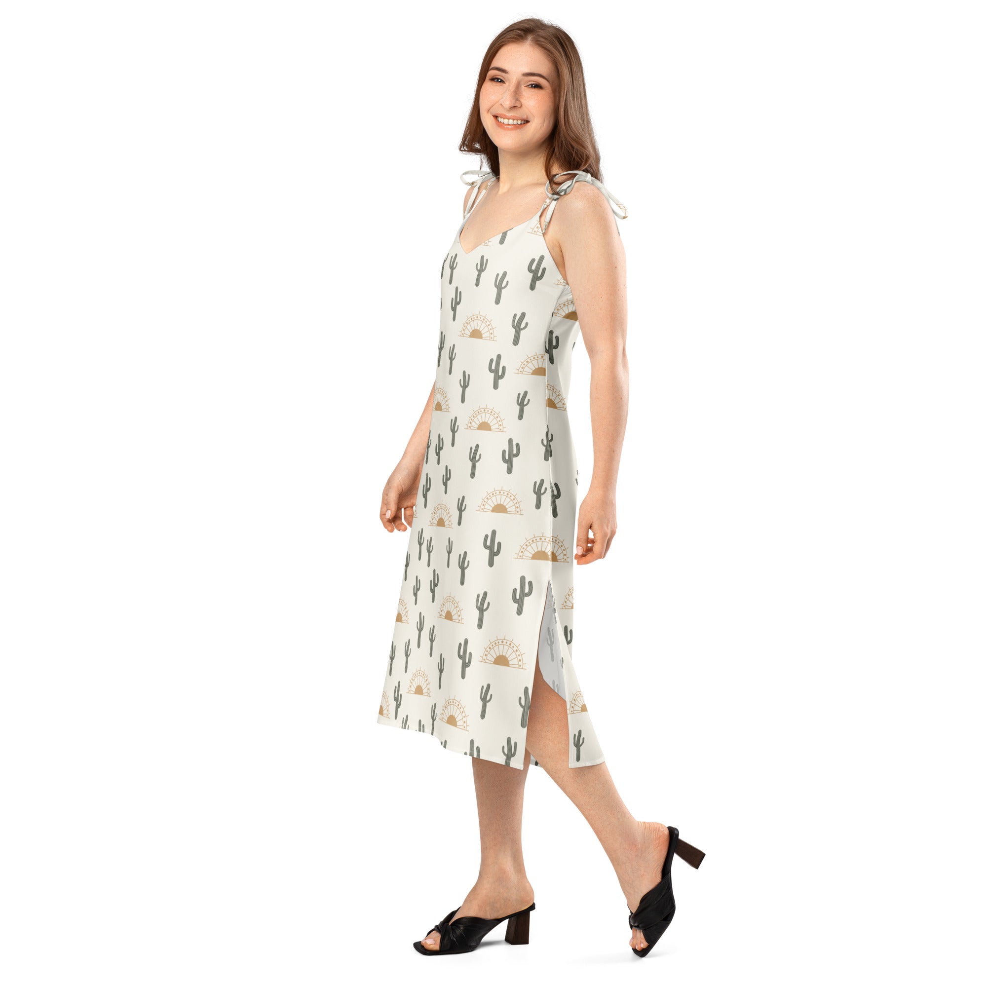A woman wearing a light-colored sleeveless midi desert cactus sunrise slip dress with adjustable tie straps and built-in bra