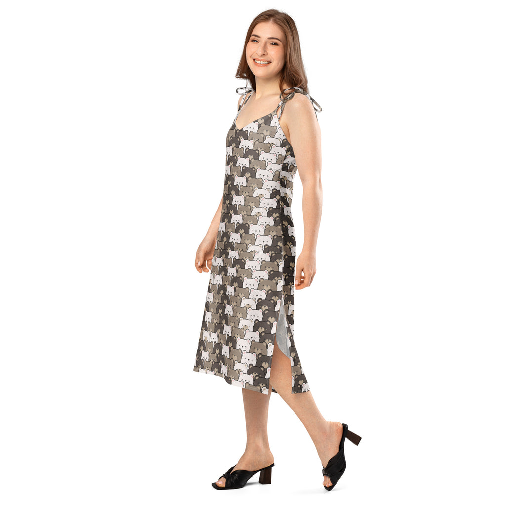 A woman wears a sleeveless midi slip dress with adjustable tie straps and built in bra featuring gray stylized cat patterns