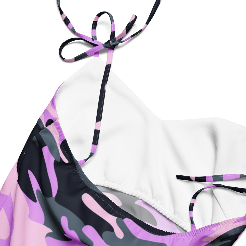A halter-style bikini top with a vibrant purple black and gray camouflage print and matching striped tie straps