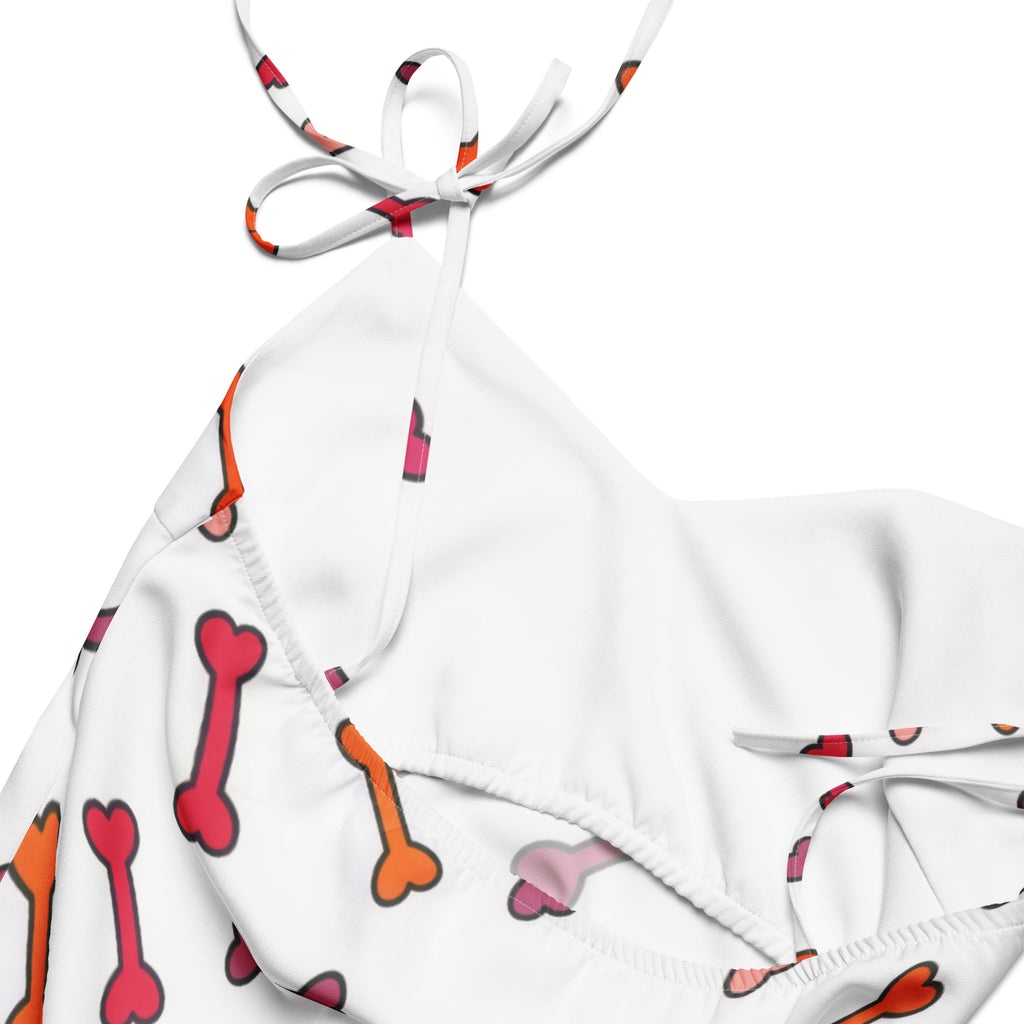 White halter top bikini with red and orange cartoon bone pattern paired with colorful dog bone slip midi dress