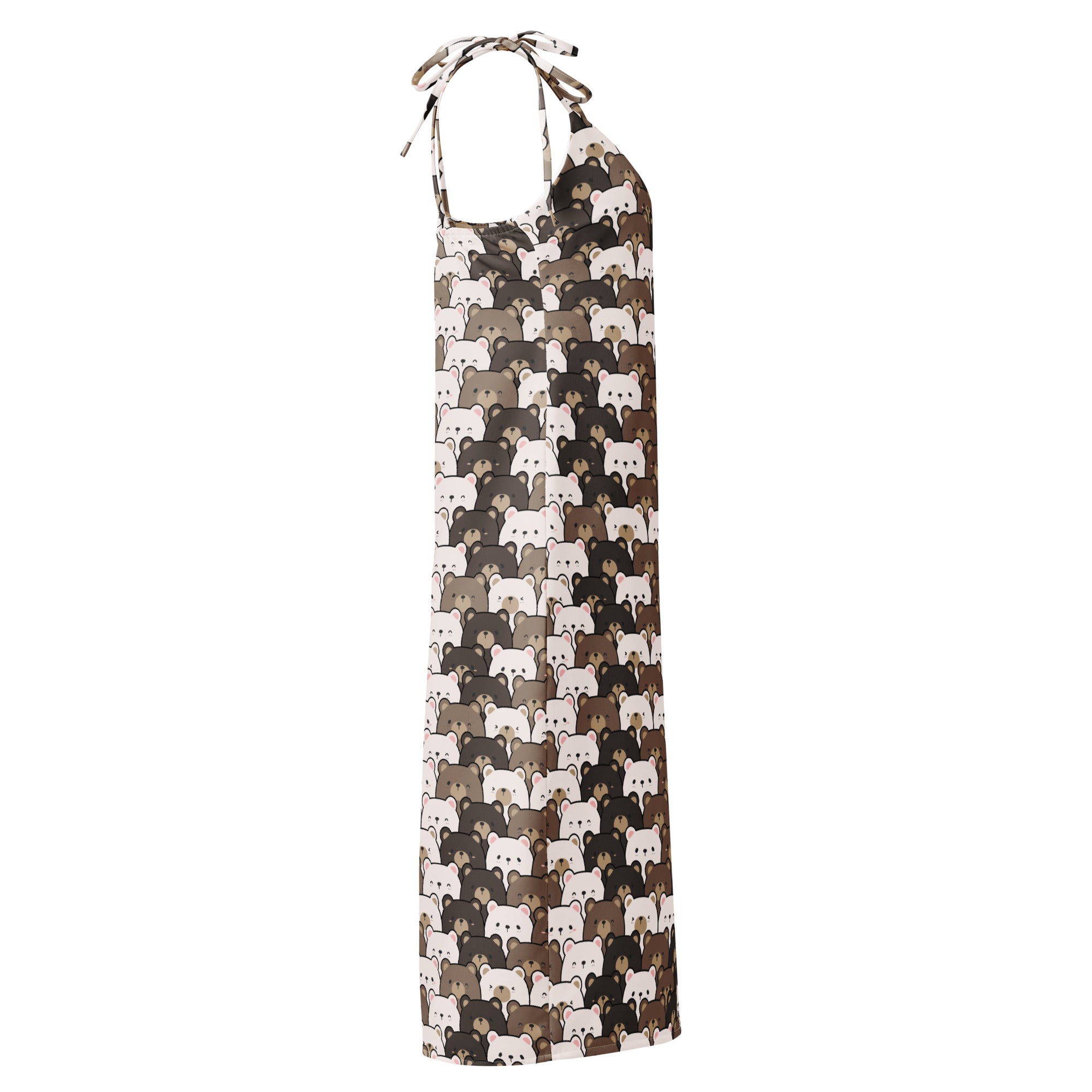 Woman wearing a light fabric midi slip dress with adjustable tie straps and a cartoon bear pattern in brown and white