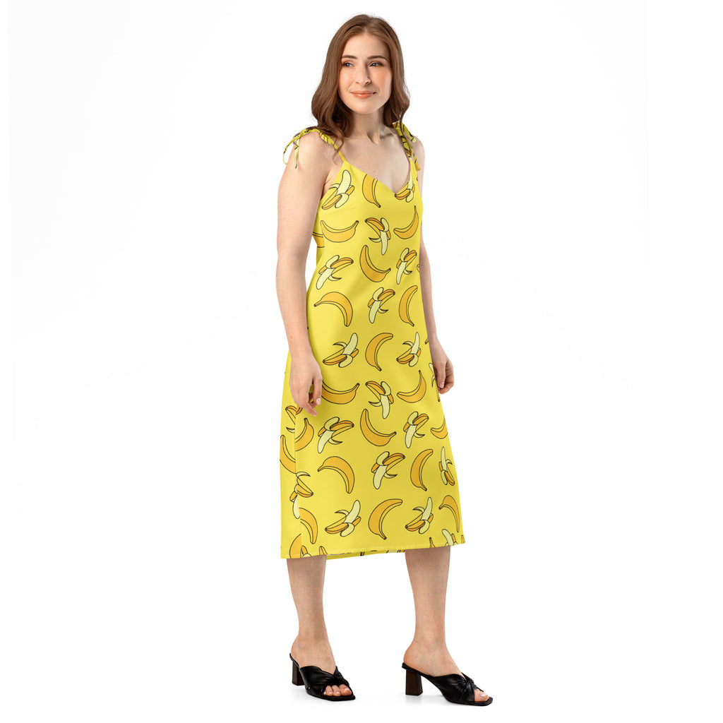 Woman wearing a yellow dress with banana pattern on a white background