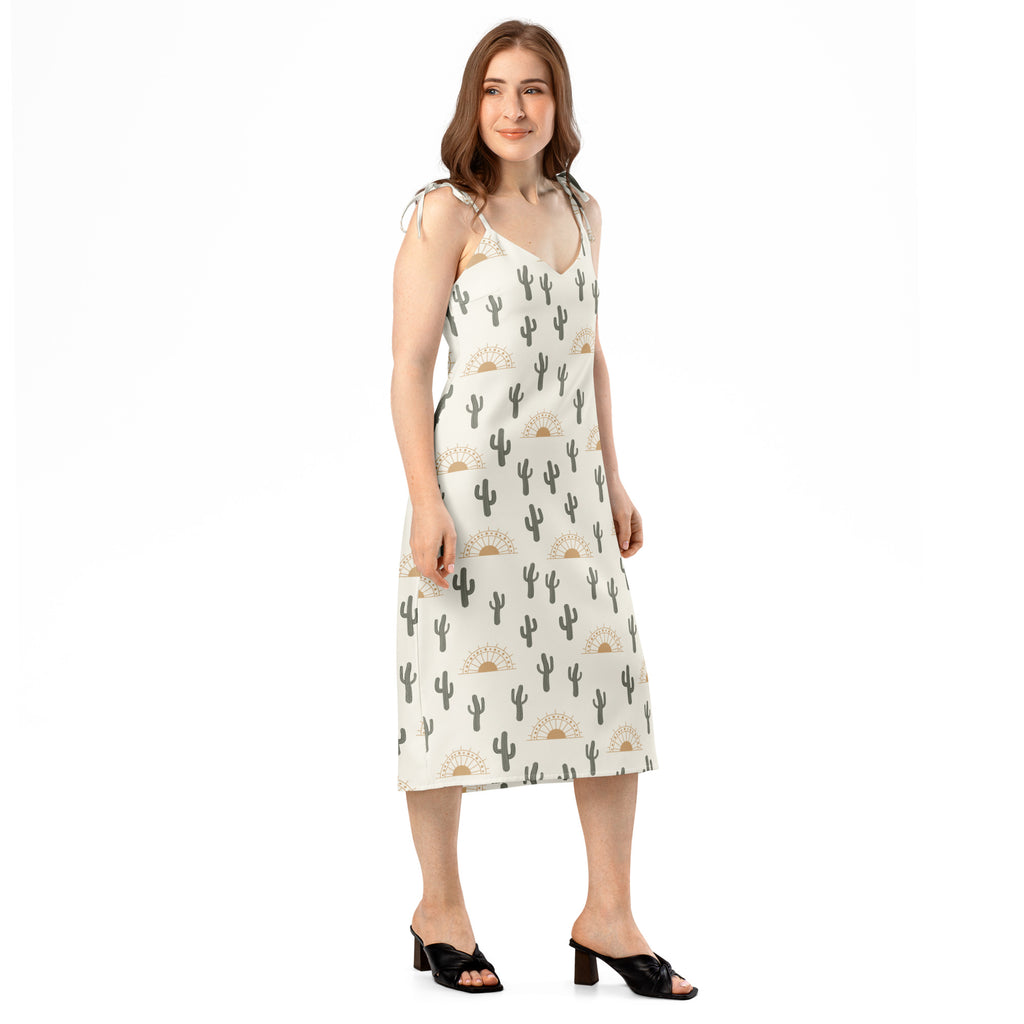 Women’s off-white midi slip dress with black cactus and beige sunburst pattern featuring adjustable tie straps and built-in bra