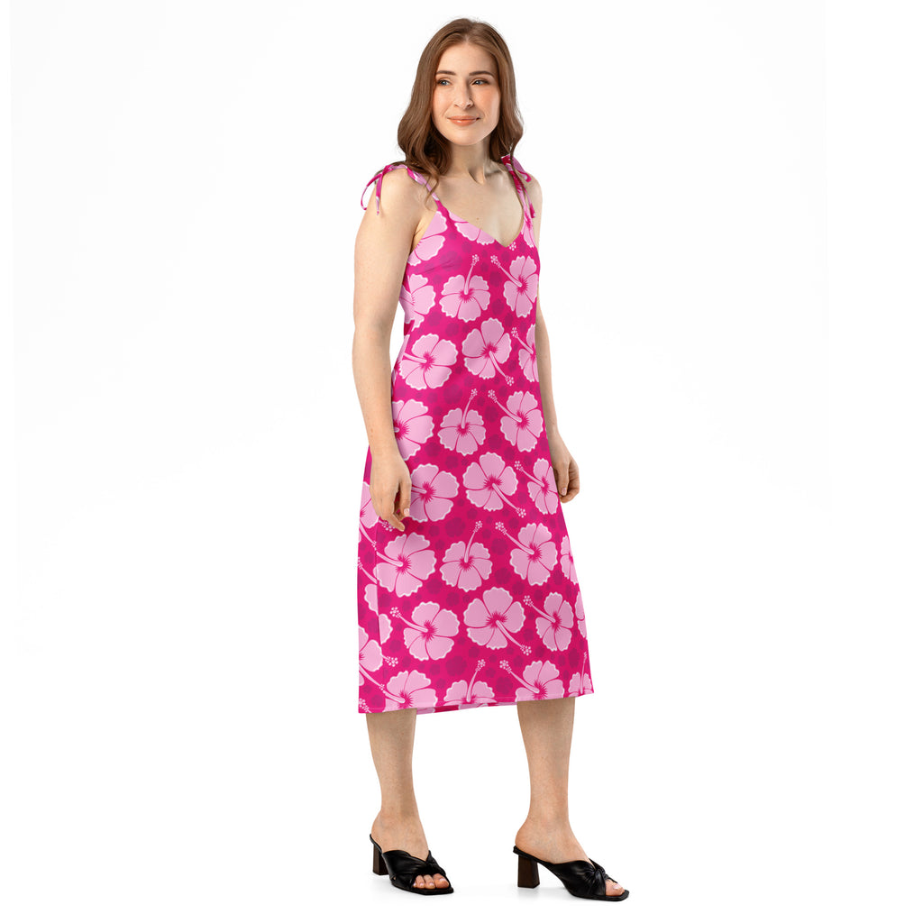A vibrant pink midi slip dress with a light pink hibiscus pattern and adjustable tie straps for women