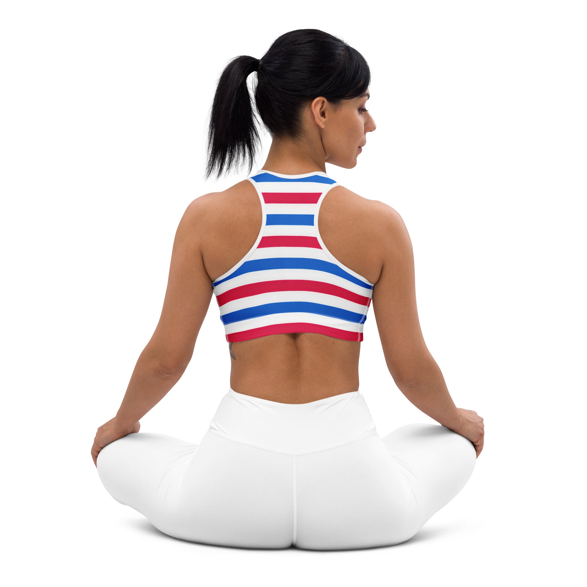 A woman wearing a red white and blue quick drying sports bra with racerback straps showing the back side