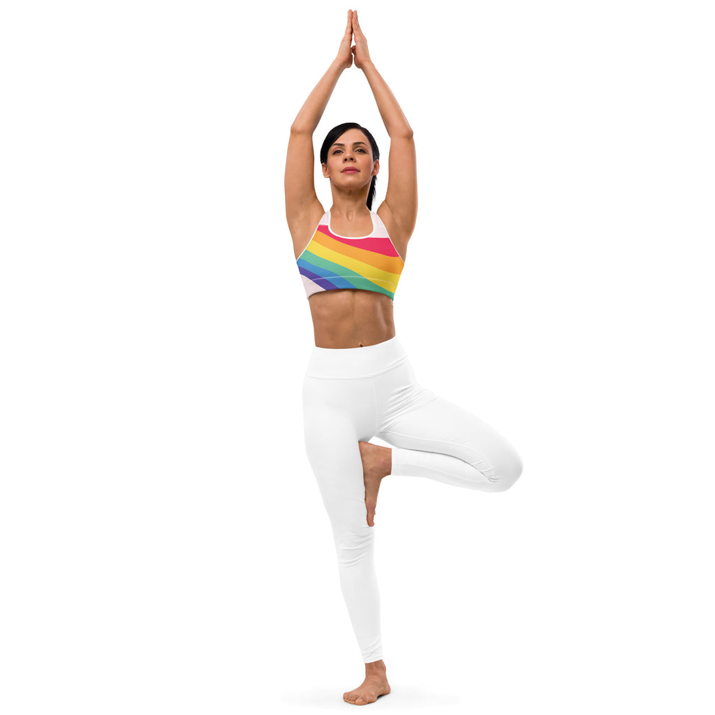 Women’s rainbow wave lgbtq quick drying sports bra with rainbow stripes paired with white leggings front view