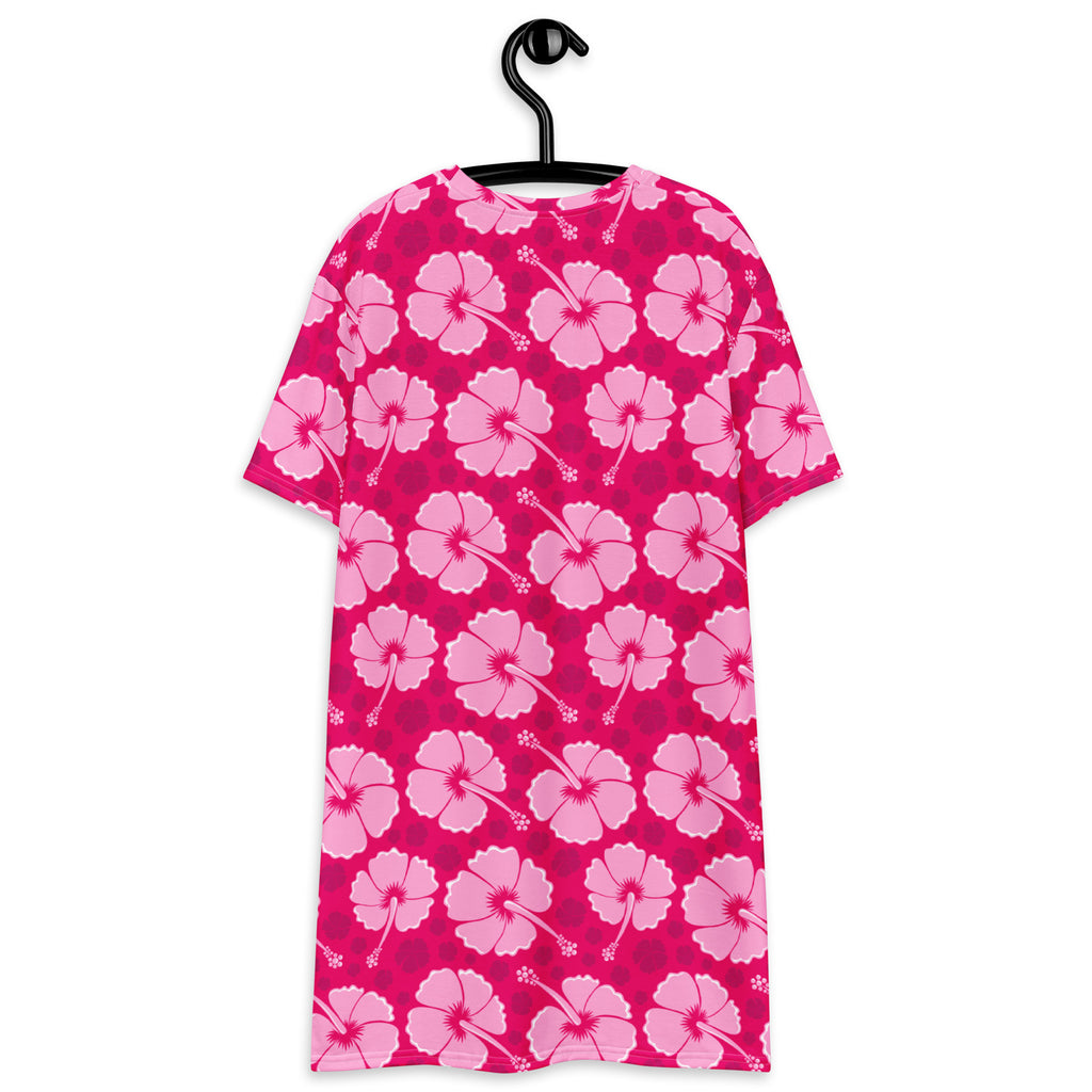 A vibrant pink tropical hibiscus t-shirt dress with short sleeves and round neckline displayed on a black hanger