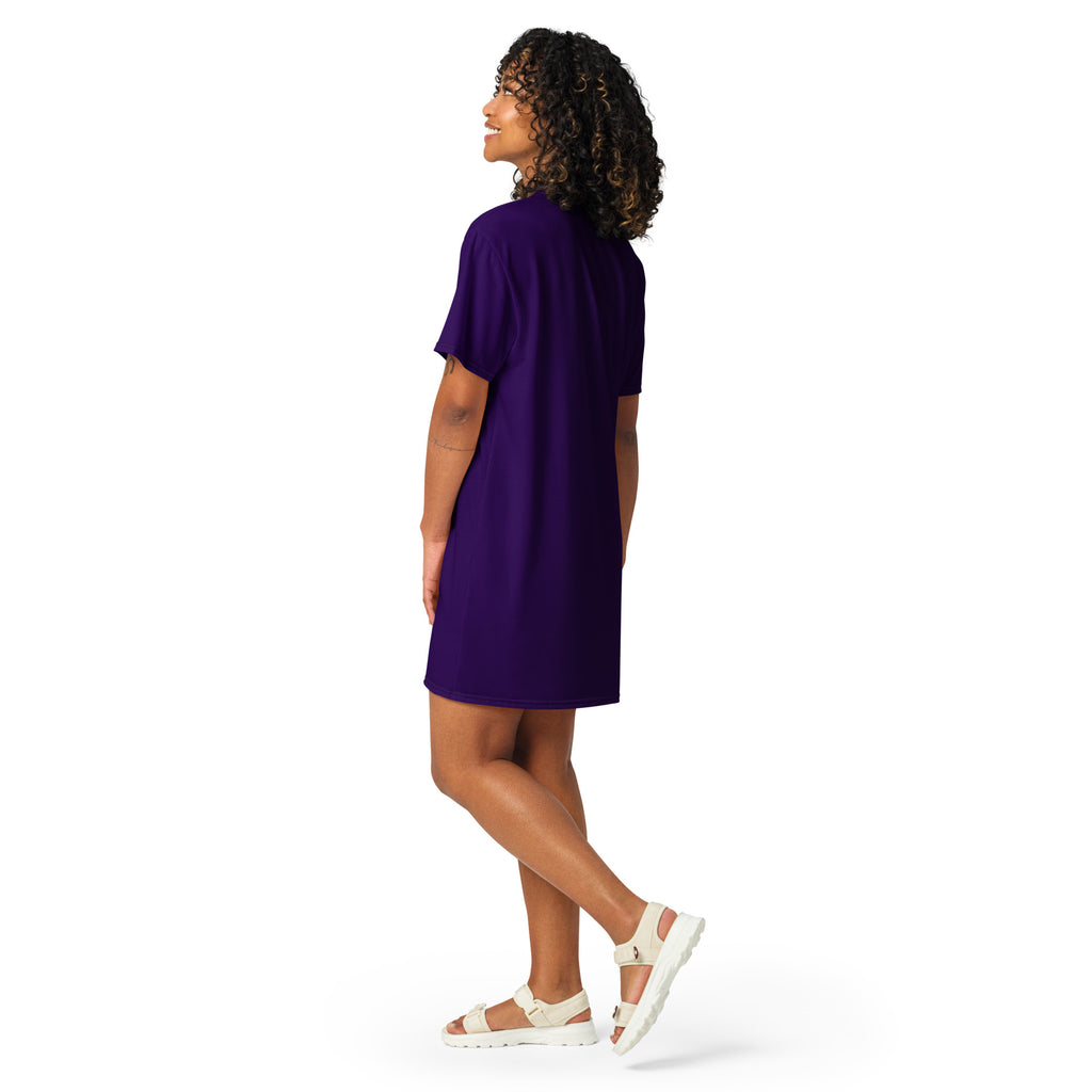 A woman wears a dark purple short-sleeved t-shirt dress with a relaxed fit and rounded neckline