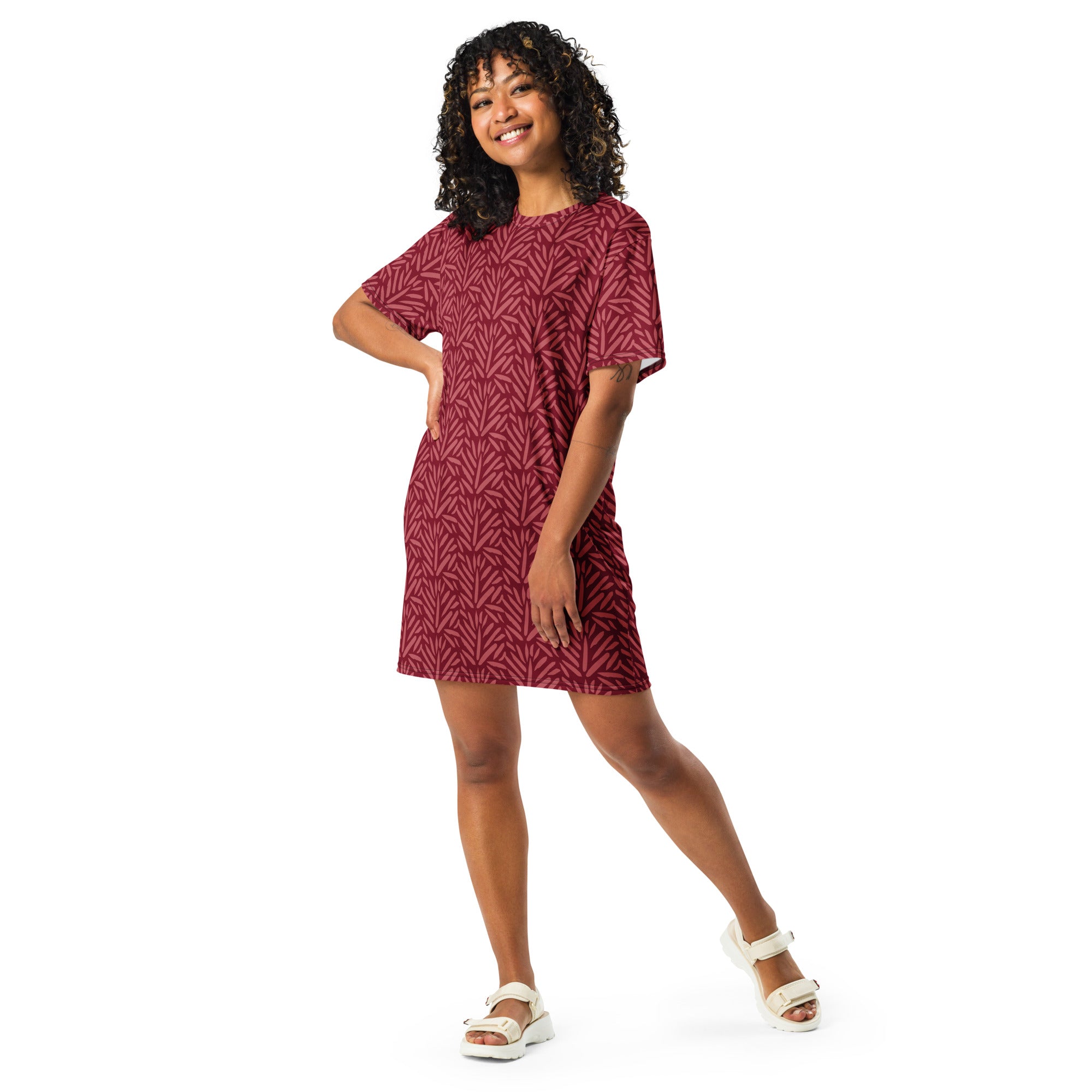 A woman wearing a women’s maroon leaf pattern t-shirt dress with short sleeves and a subtle geometric leaf design