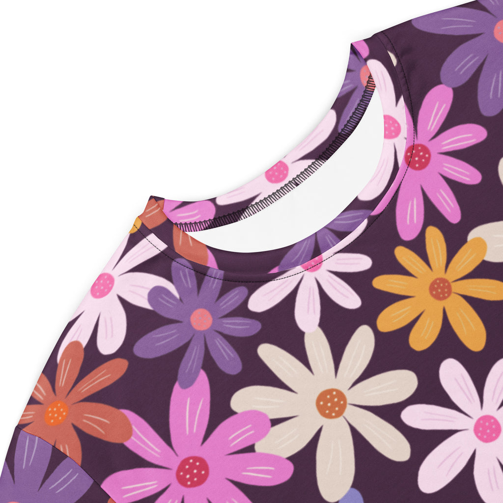 Women’s retro floral t-shirt dress with round neckline featuring colorful pink purple yellow and white daisies on dark background