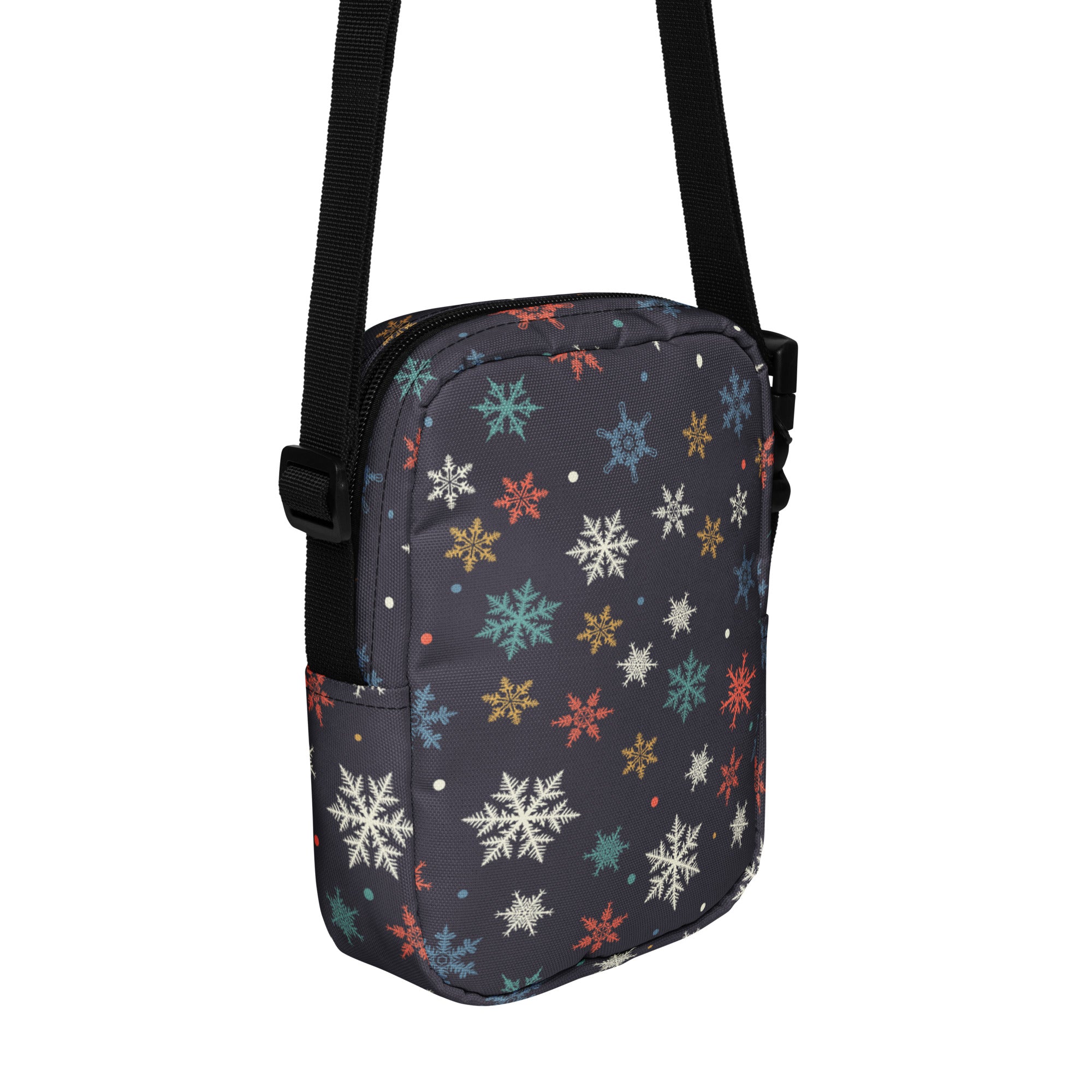 A dark gray crossbody purse with a colorful pattern of white teal orange and gold snowflakes for women