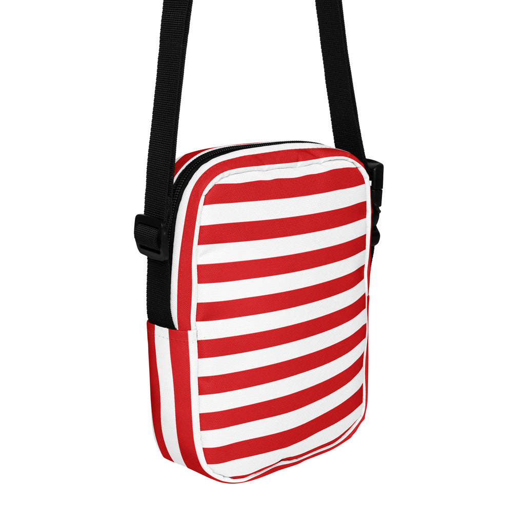 Red and white candy stripe crossbody purse with black strap featuring horizontal stripes for christmas use