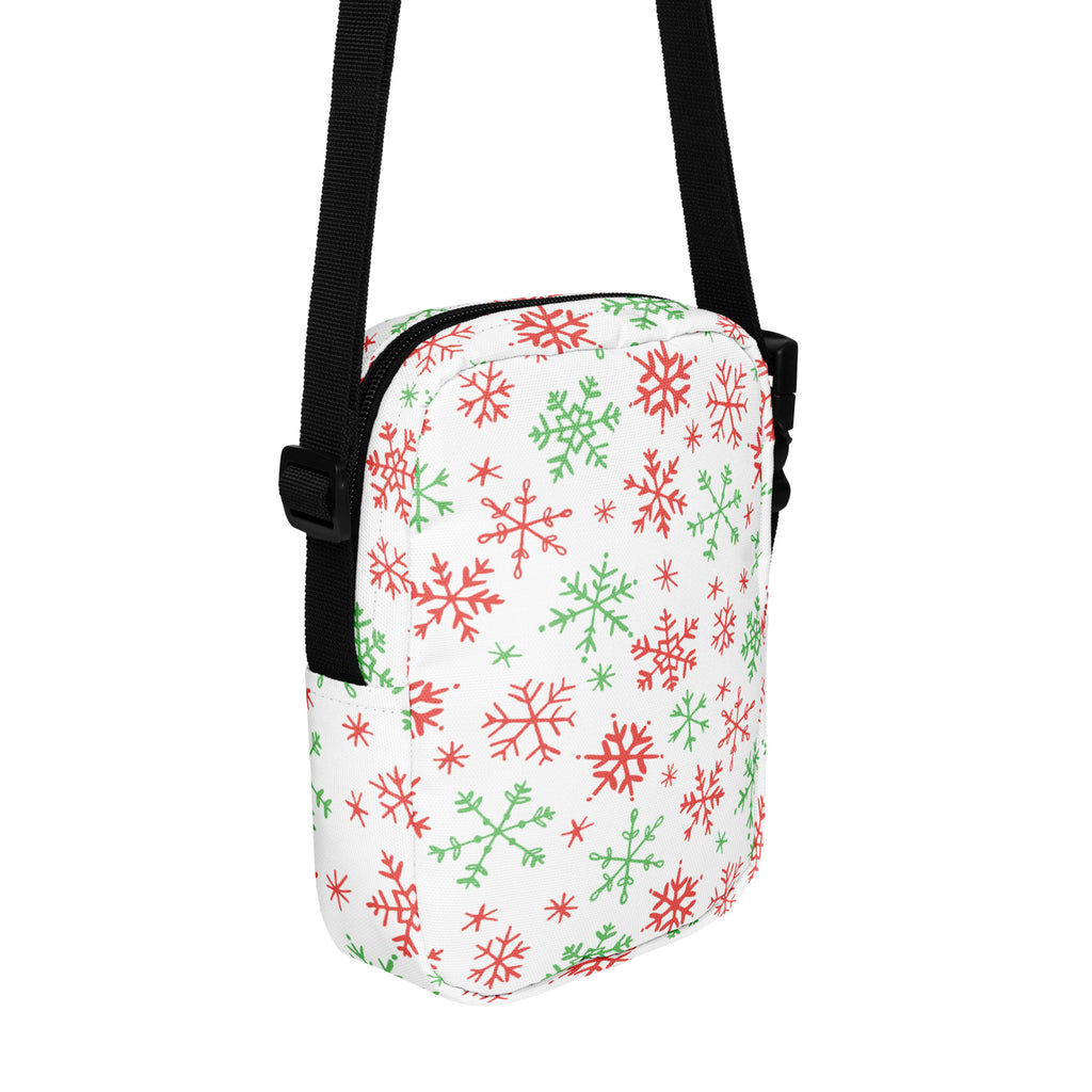 White crossbody bag with red and green snowflake pattern on fabric and black straps festive Christmas purse
