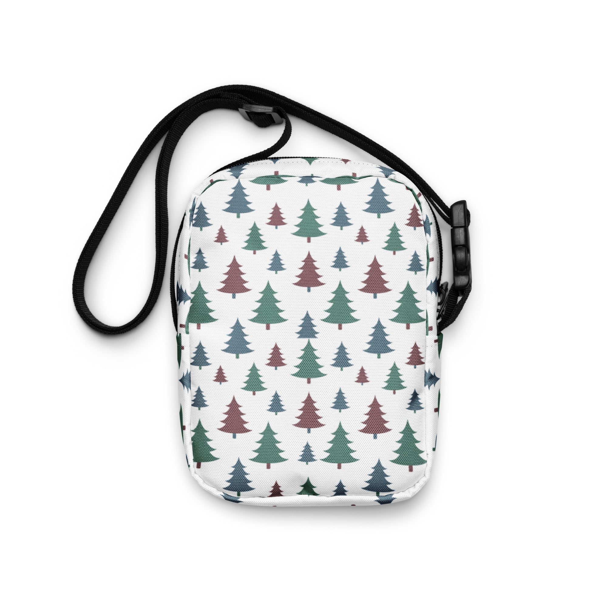 White crossbody bag with green and maroon pine tree pattern on textured fabric with black adjustable strap