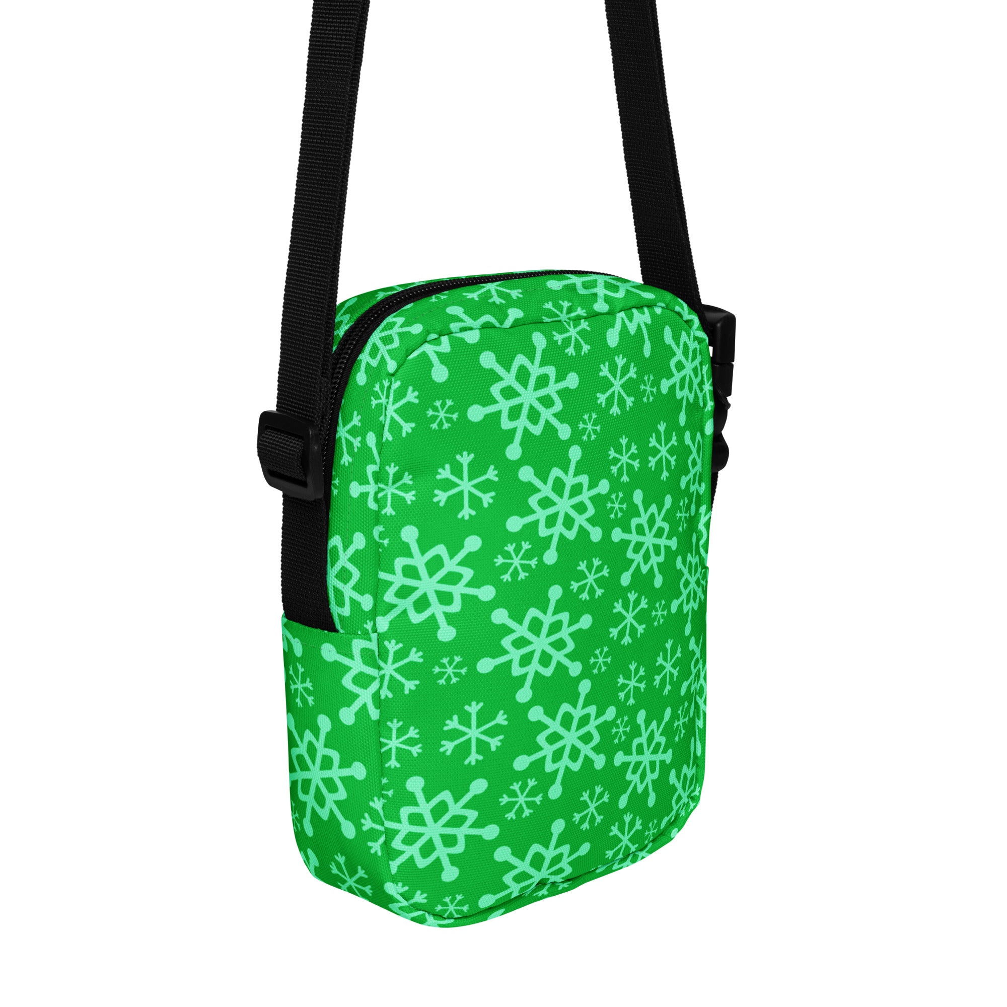 A green snowflake Christmas women’s crossbody purse with mint snowflake pattern and black straps and zipper hardware