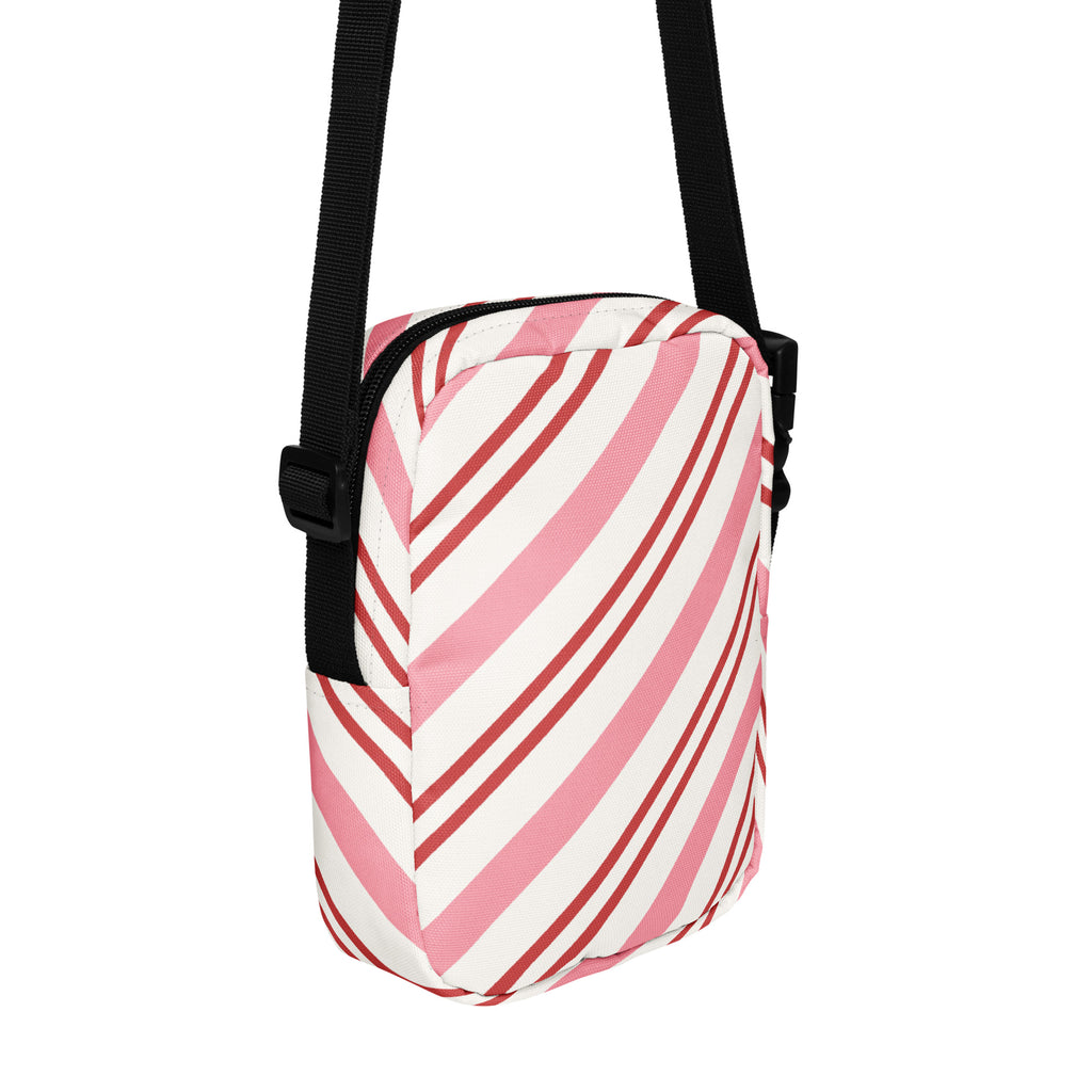 Pink candy cane stripe christmas women’s crossbody purse with pink and white stripes and a black adjustable strap