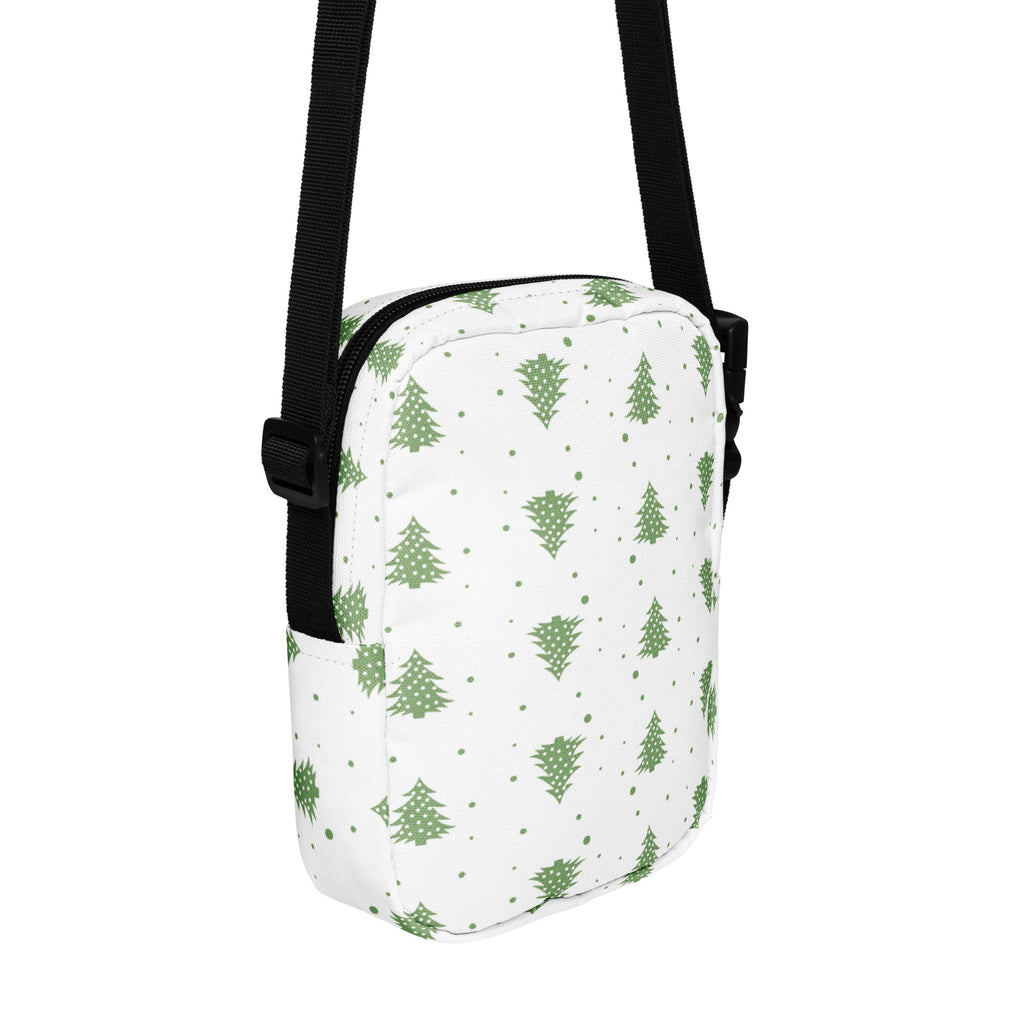 White crossbody bag with green pine tree and dot pattern and black adjustable strap for winter use
