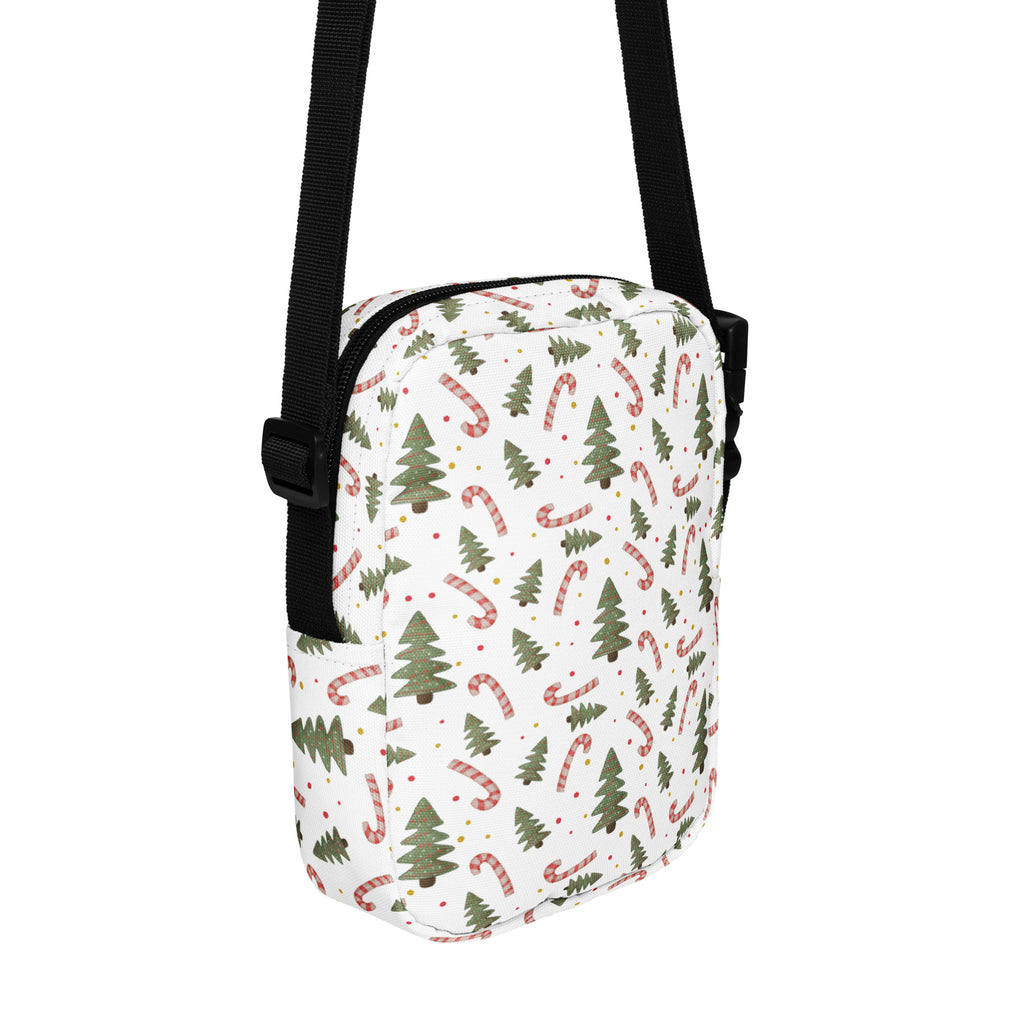 White crossbody bag with festive green pine trees and red and white striped candy canes holiday pattern