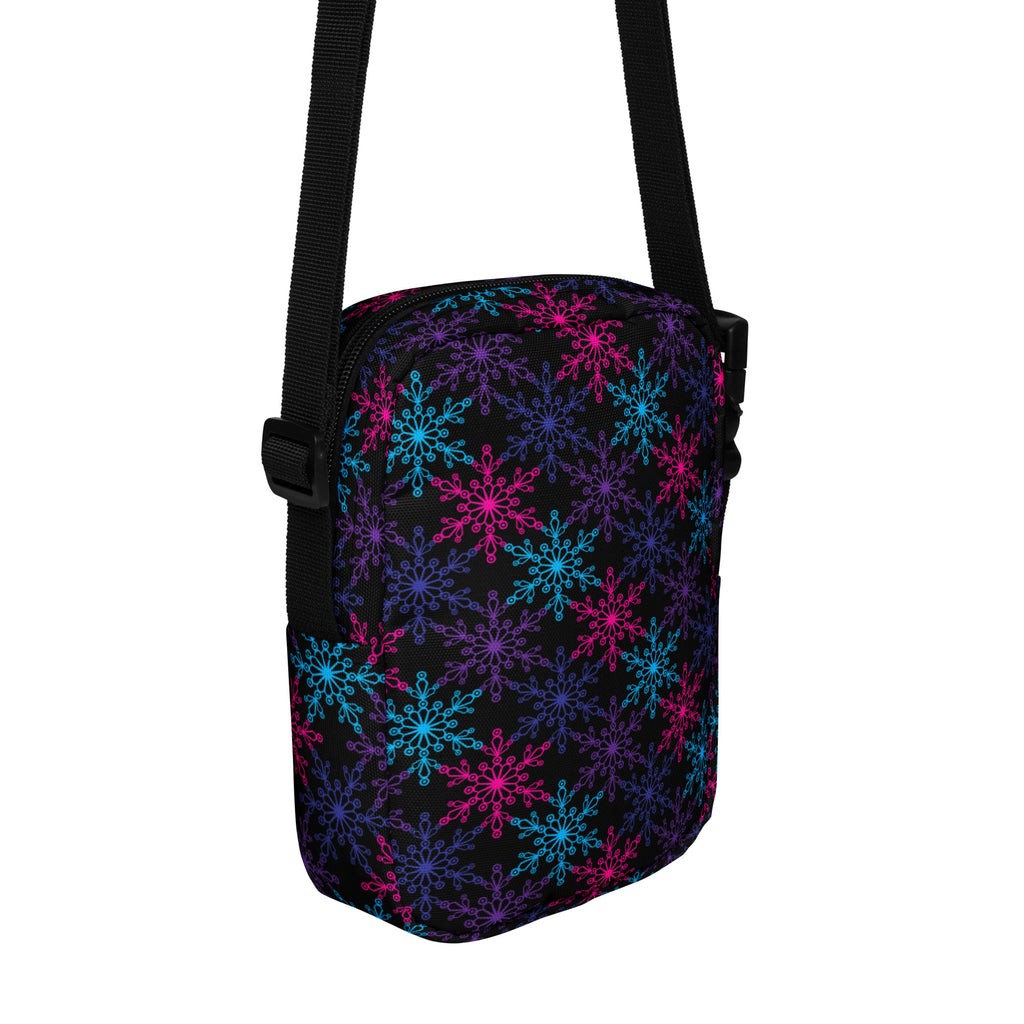 A black girls crossbody purse with vibrant neon pink blue and purple snowflake pattern for casual use