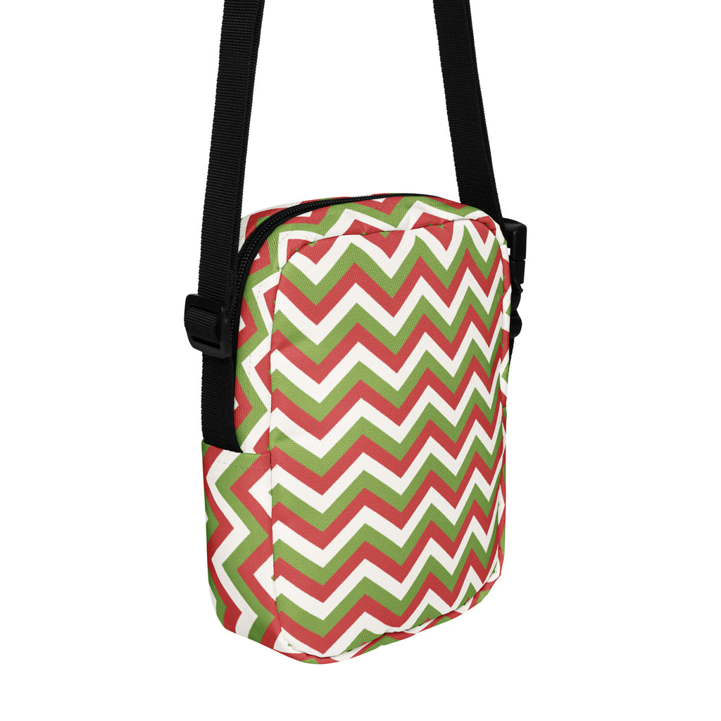 A girls Christmas chevron crossbody purse with a compact design and red green and white zigzag fabric pattern