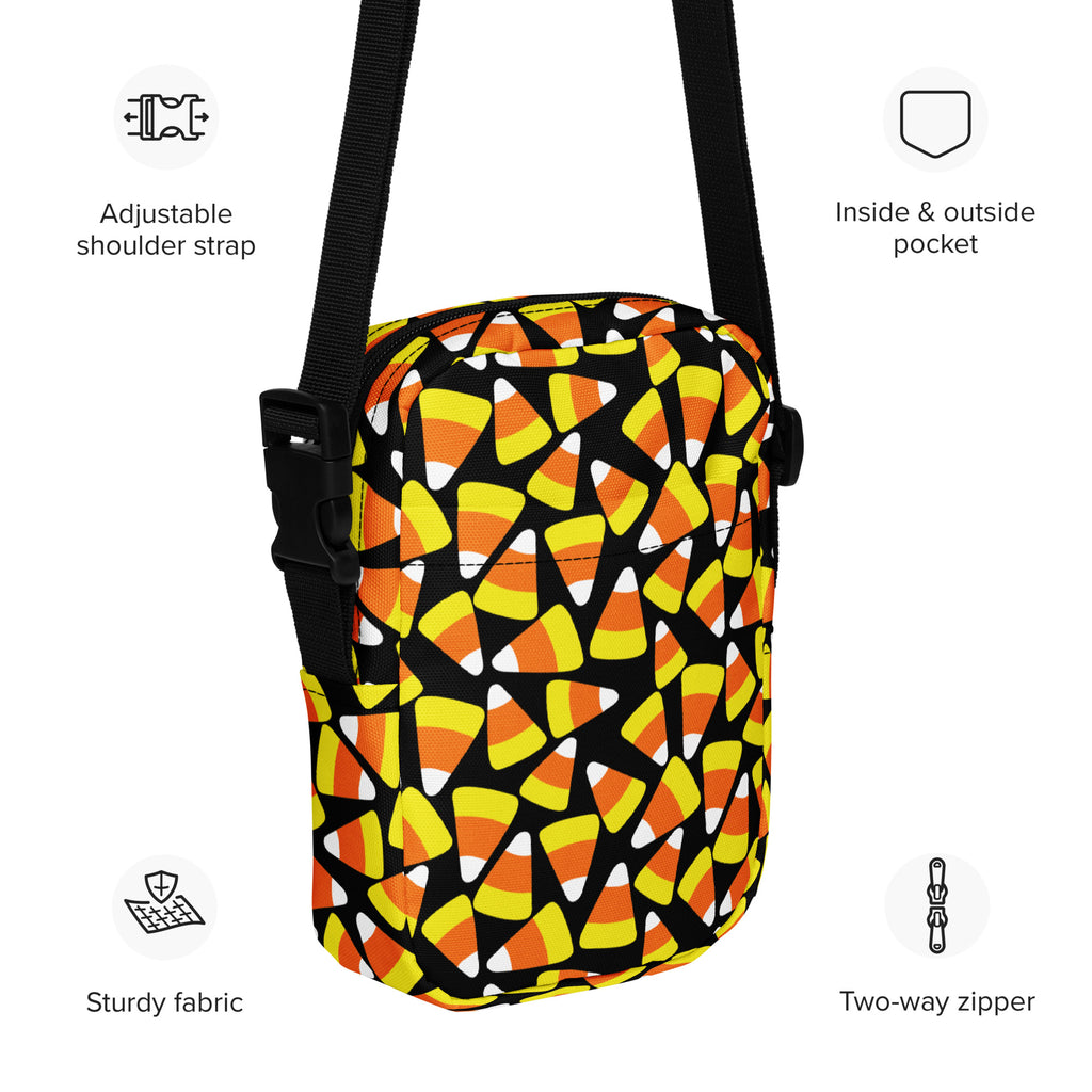 A black crossbody bag with a vibrant orange yellow and white candy corn pattern for girls halloween use