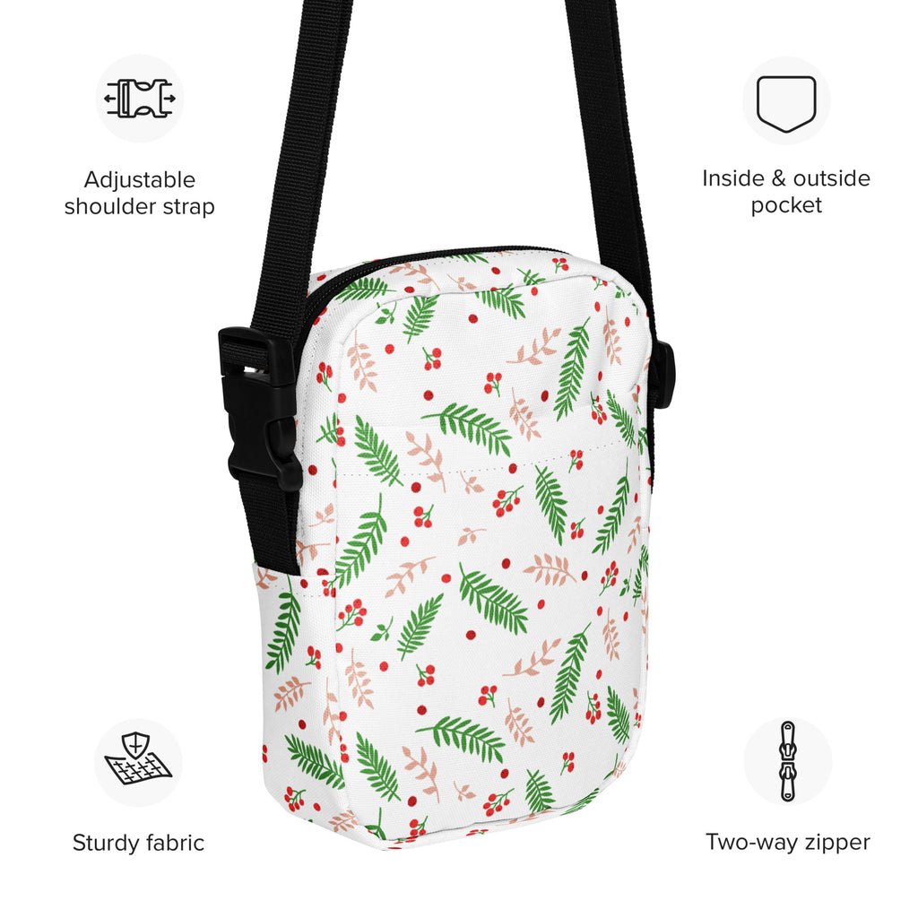 White winter fern and berry women’s crossbody purse with green and pink leafy berry pattern and black adjustable straps