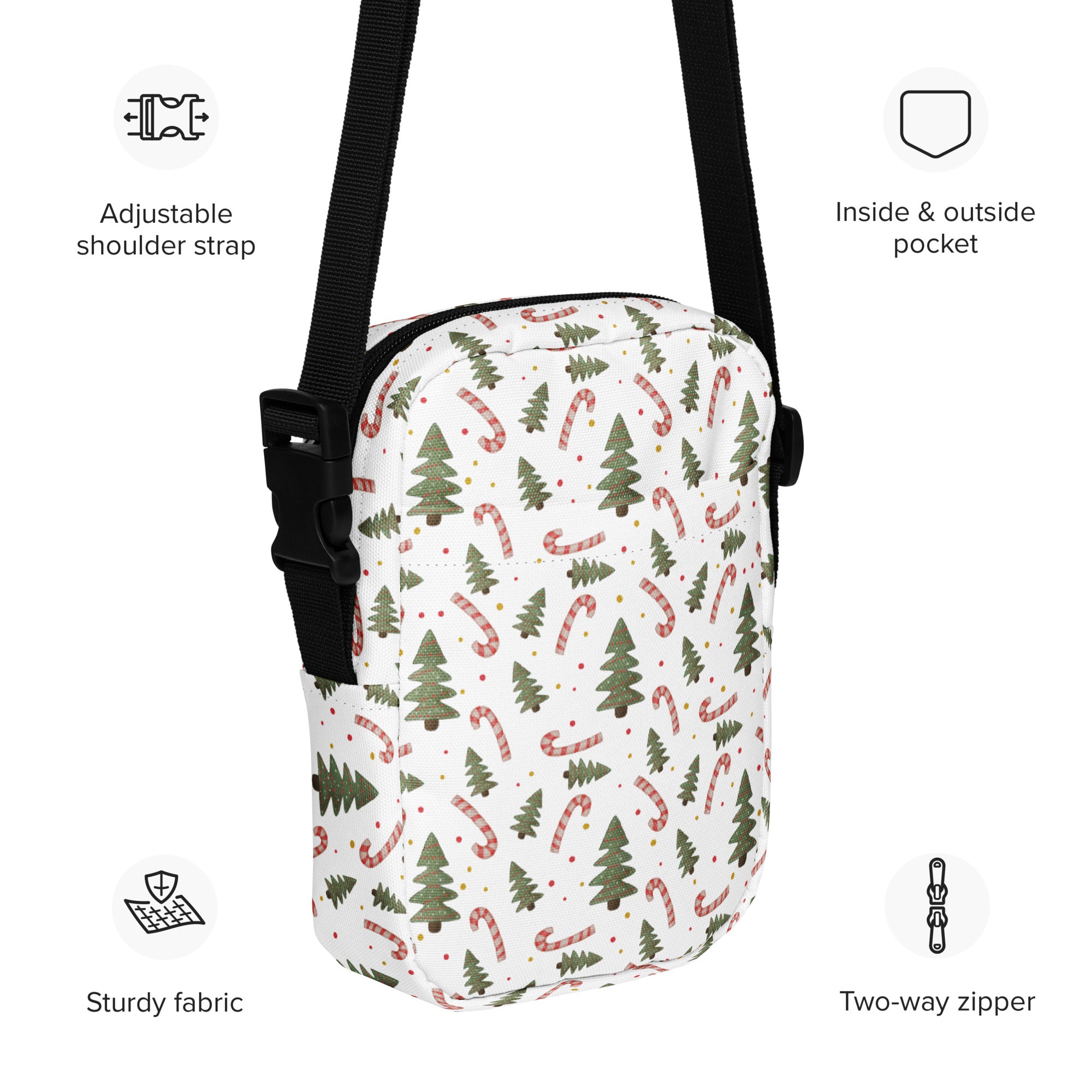 White crossbody bag with green pine trees and red candy canes on sturdy fabric and an adjustable black strap