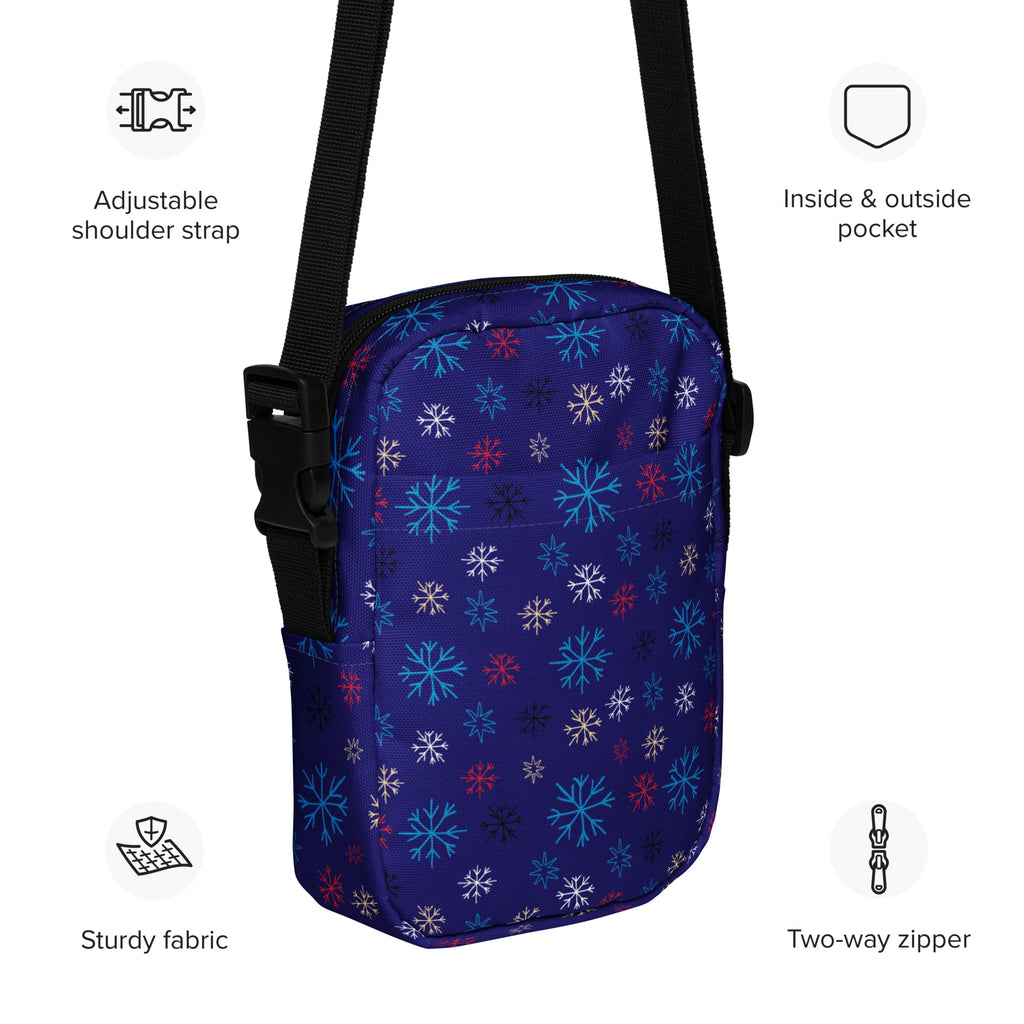A navy blue crossbody purse with multicolored snowflake pattern for Christmas winter use in women