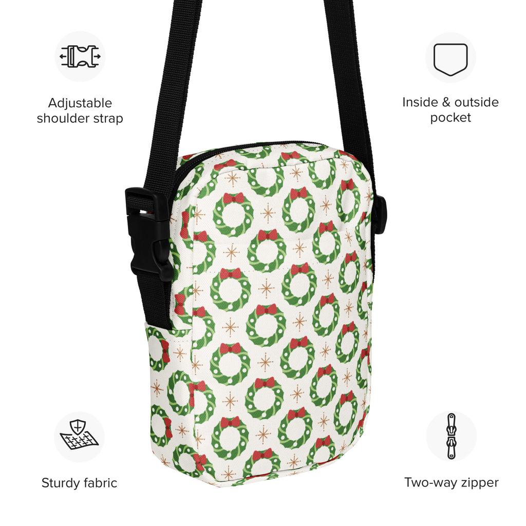 White crossbody purse with festive green wreath pattern red bows and gold stars made from sturdy fabric for Christmas use