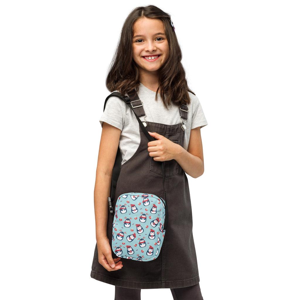 Light blue girls reindeer penguin crossbody purse with black straps featuring a penguin pattern for everyday use