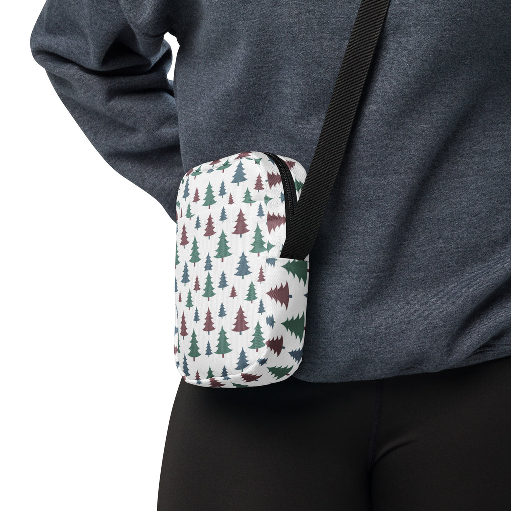 A compact white Christmas Trees winter women’s crossbody purse with green and maroon pine tree pattern and black strap