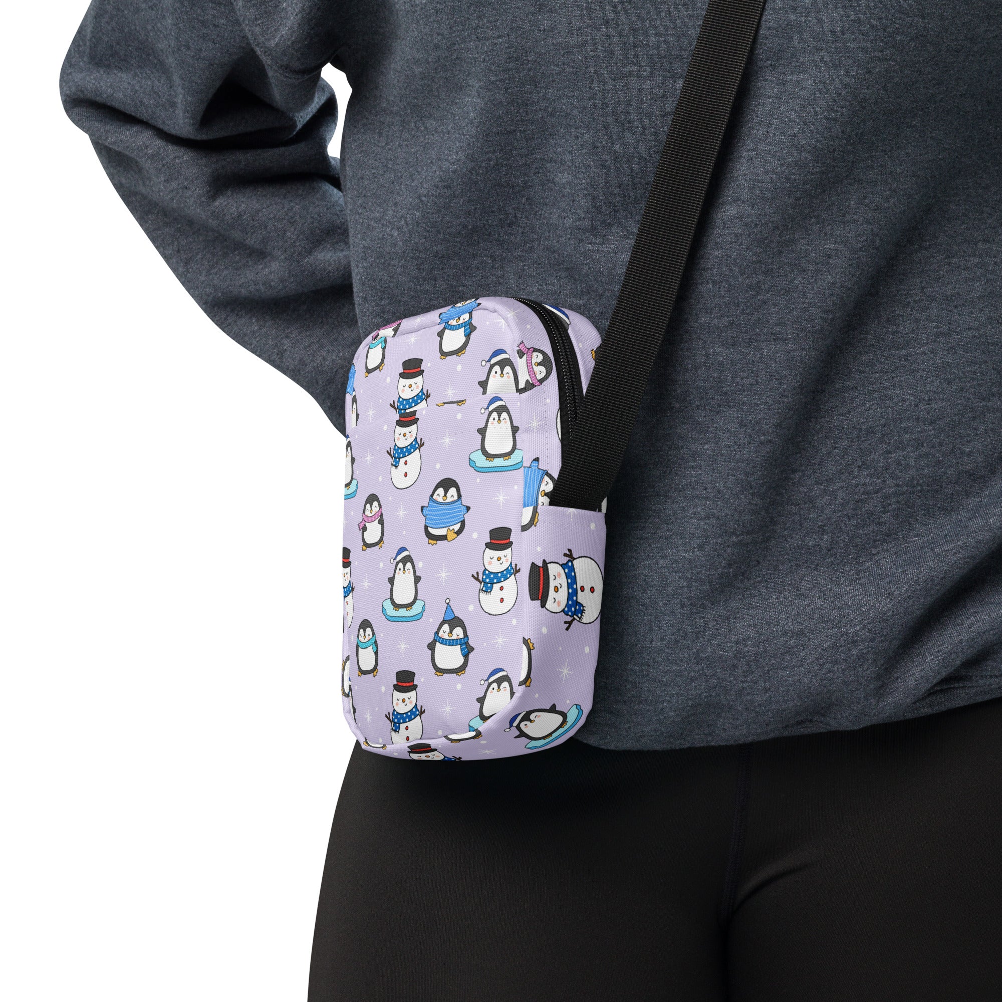 Lavender crossbody pouch featuring a playful pattern of cartoon penguins and snowmen in winter outfits