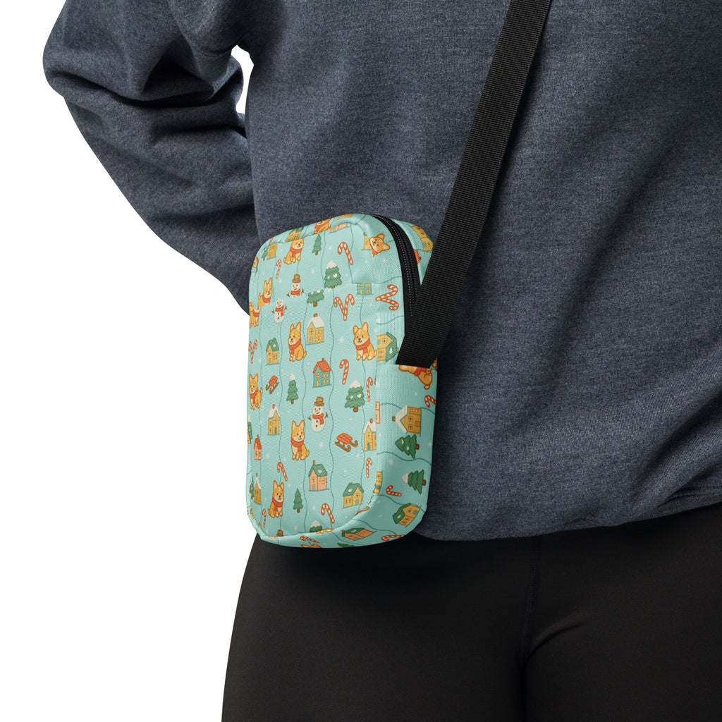 A teal crossbody bag with a playful pattern of cartoon corgis christmas trees and candy canes for women